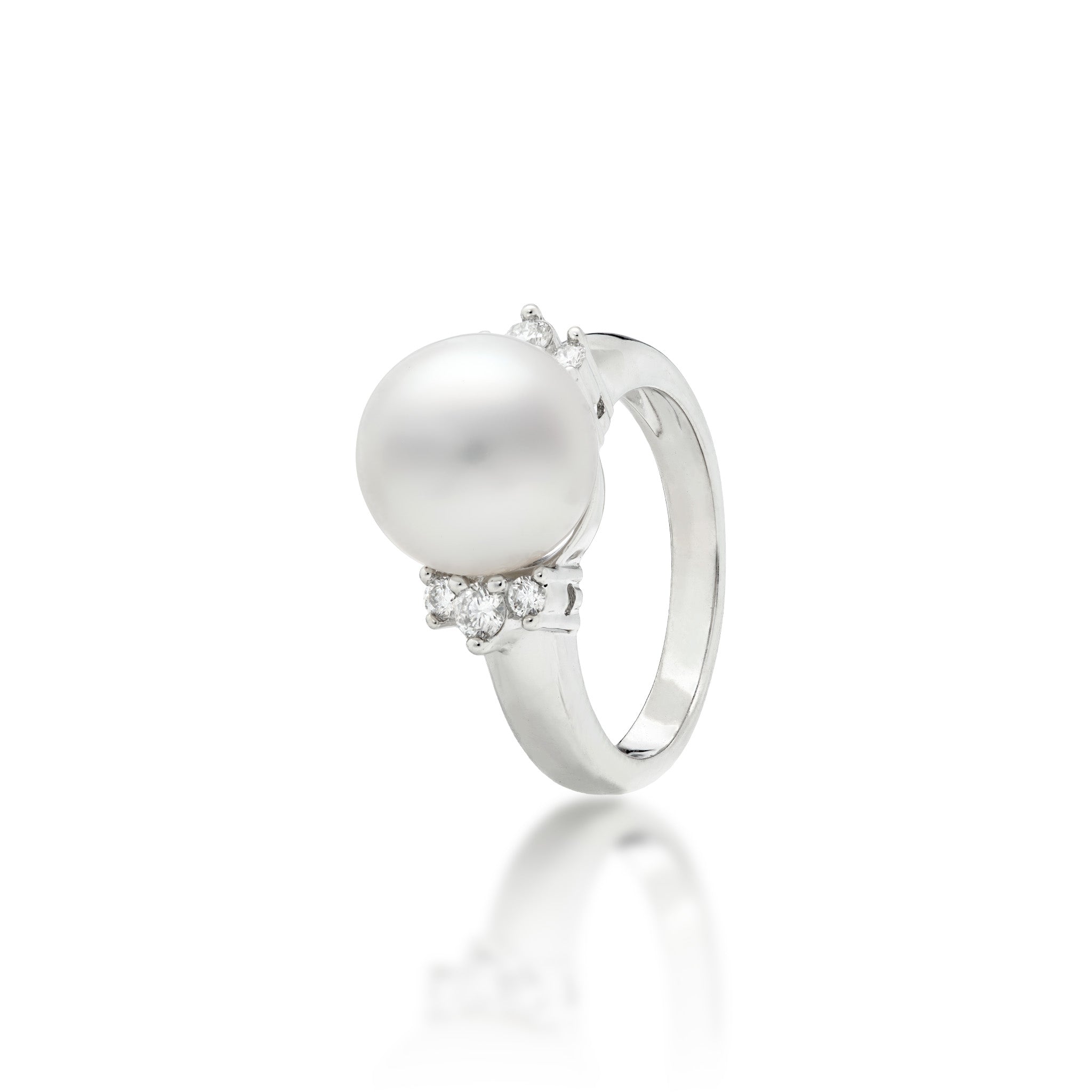 A 14k white gold ring featuring a large, lustrous South Sea White pearl as the center stone, accented by three diamonds on either side of the band, set against a clean white background with a soft reflection below.