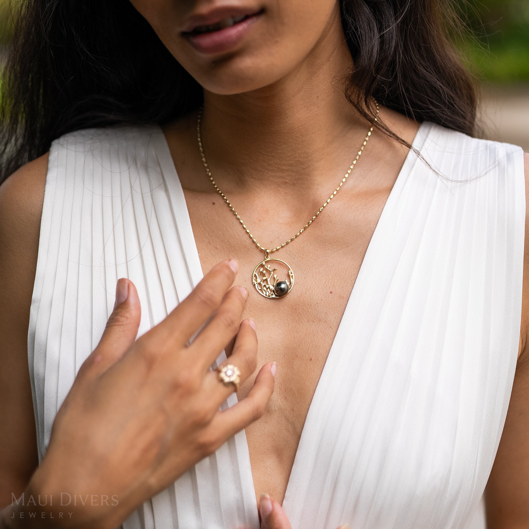 Close up of a woman's chest featuring a 30mm Reefs Tahitian Black Pearl Pendant in Gold with Diamonds