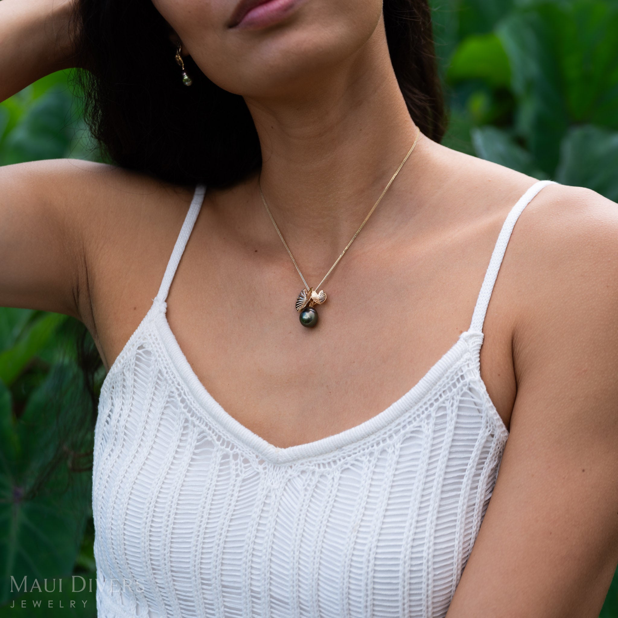 Woman in a garden wearing a Kalo 12-15mm Circle Tahitian Black Pearl Pendant in Gold