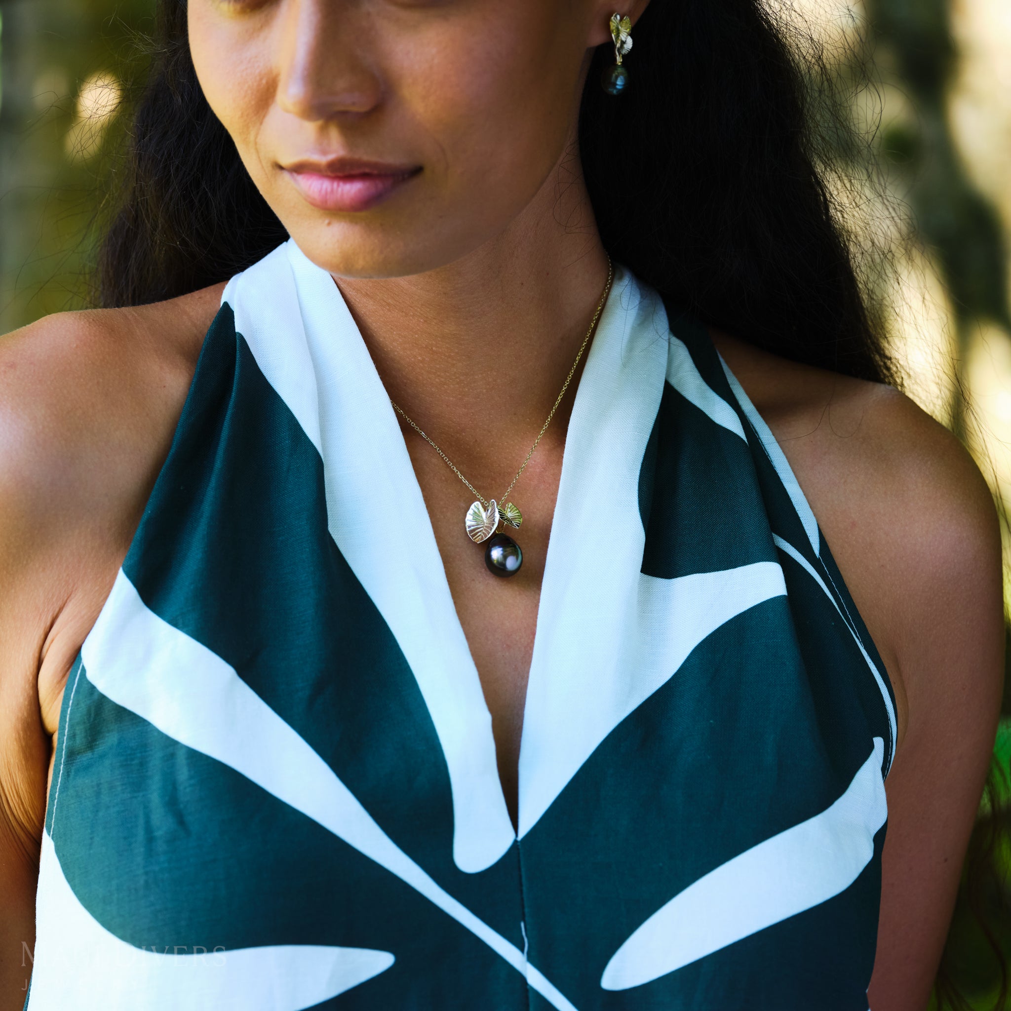Woman wearing a green and white patterned top with a Kalo 12-15mm Circle Tahitian Black Pearl Pendant in Gold