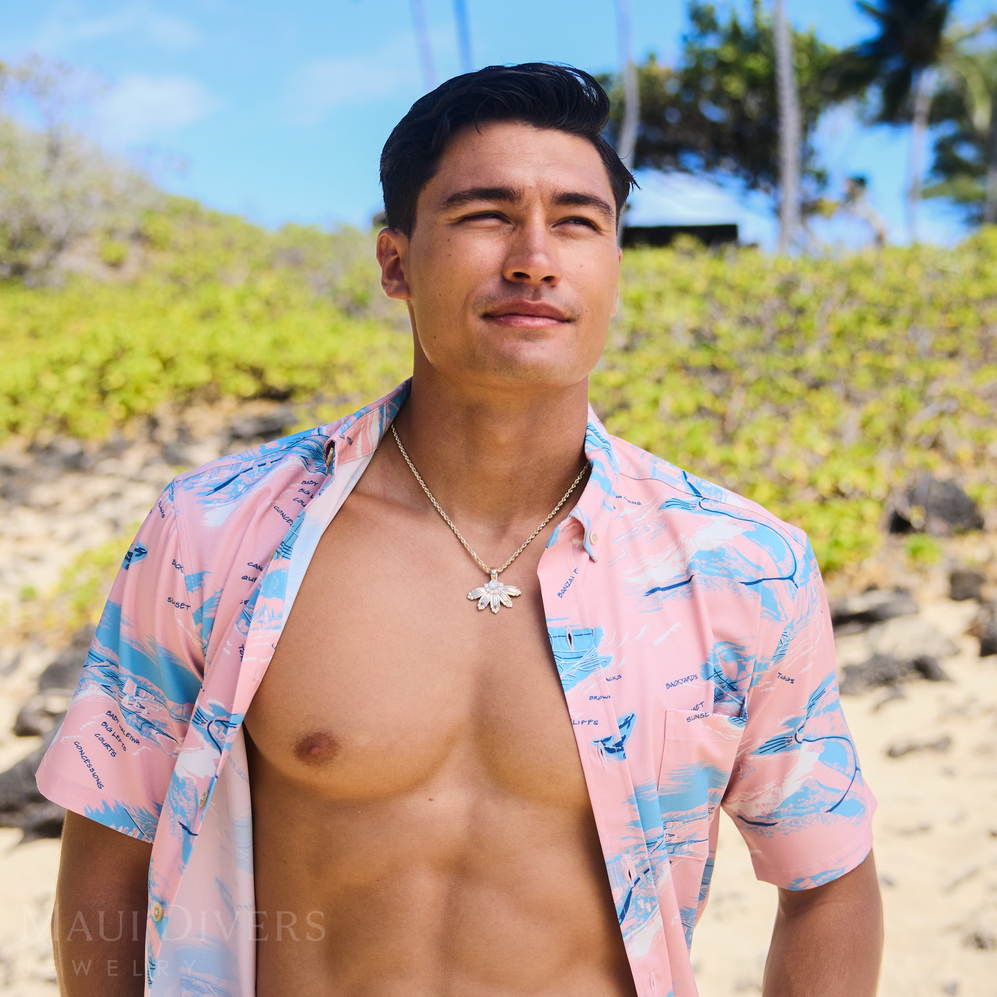 Man at the beach wearing a Mountain Naupaka Pendant in Gold with Lab Grown Diamonds