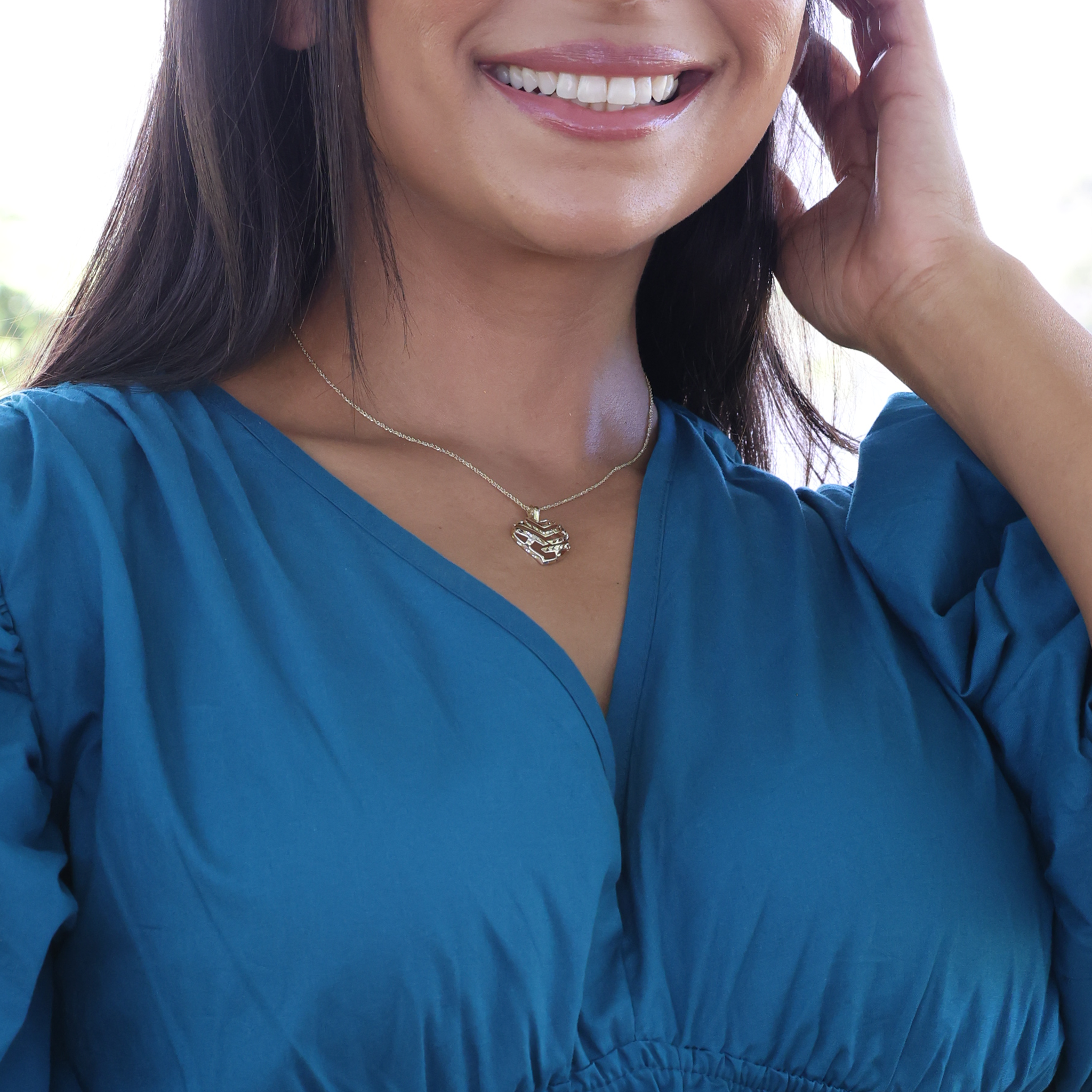 Close up of woman wearing yellow gold Aloha Heart Pendant with cut-out design on chain