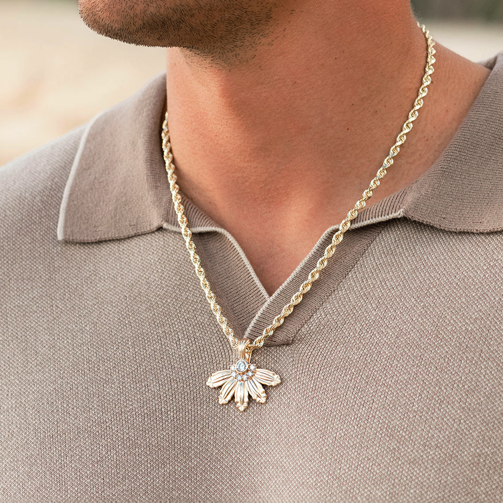 Close up of man wearing a Mountain Naupaka Pendant in Gold with Lab Grown Diamonds on rope chain