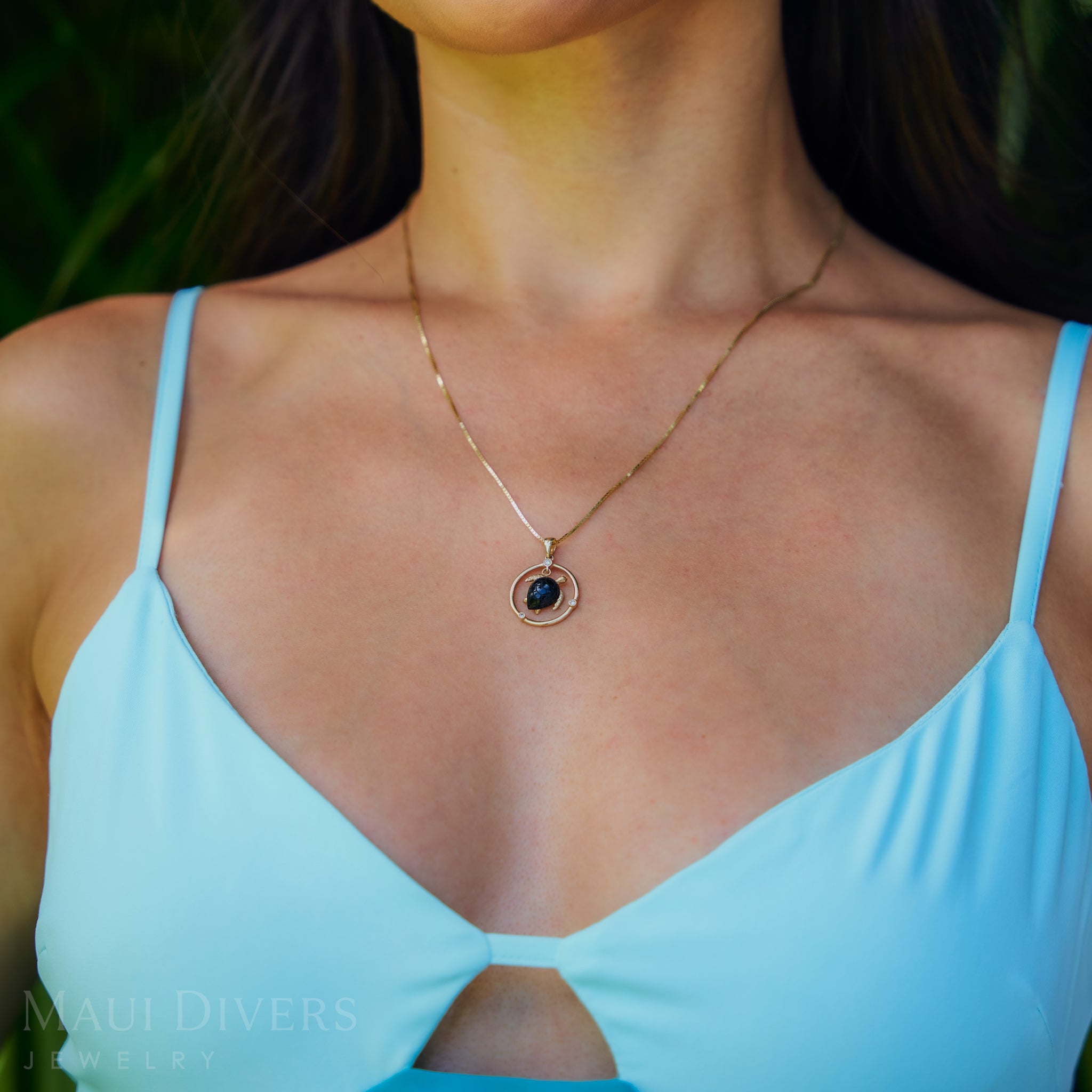 0.85mm Box Chain in 14k Yellow Gold with a turtle pendant on a womanʻs chest