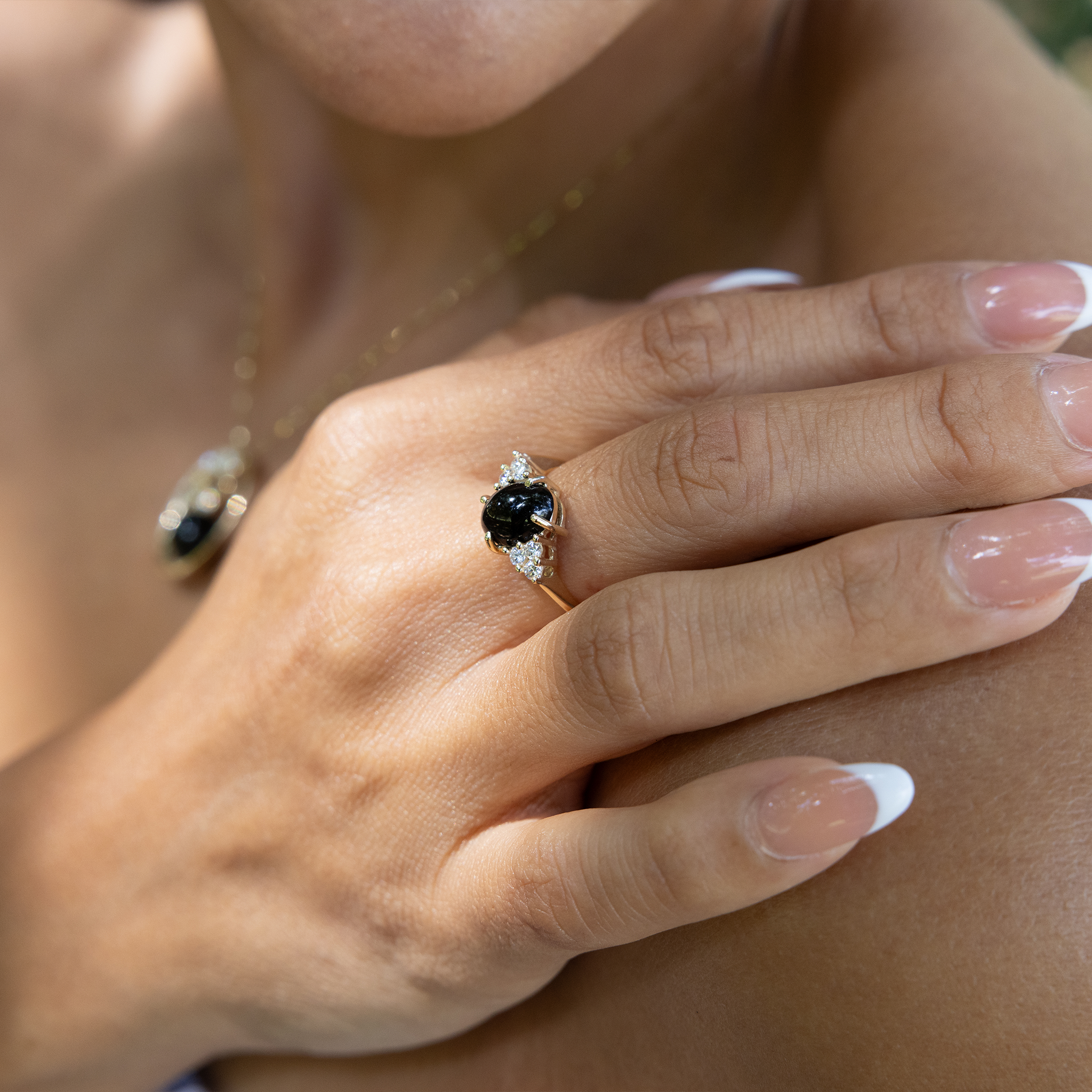 Hand wearing Black Coral Ring in Gold with Diamonds