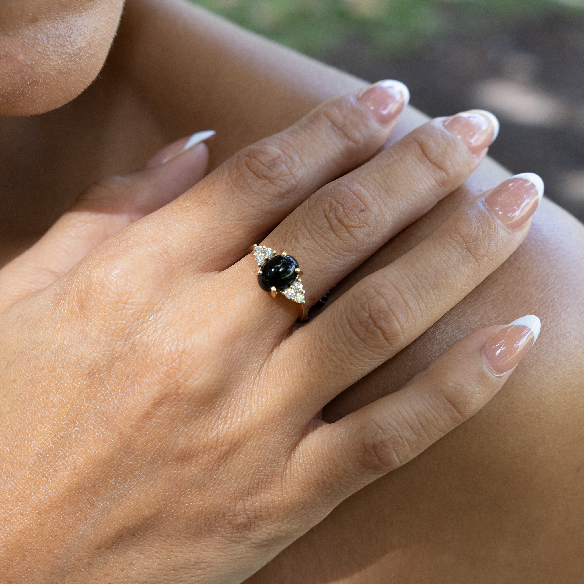 Hand wearing Black Coral Ring in Gold with Diamonds