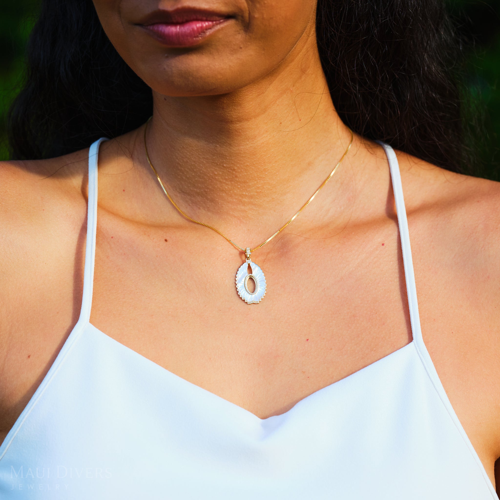 Close up of Pueo (Owl) Mother of Pearl Pendant in Gold with Diamonds on woman