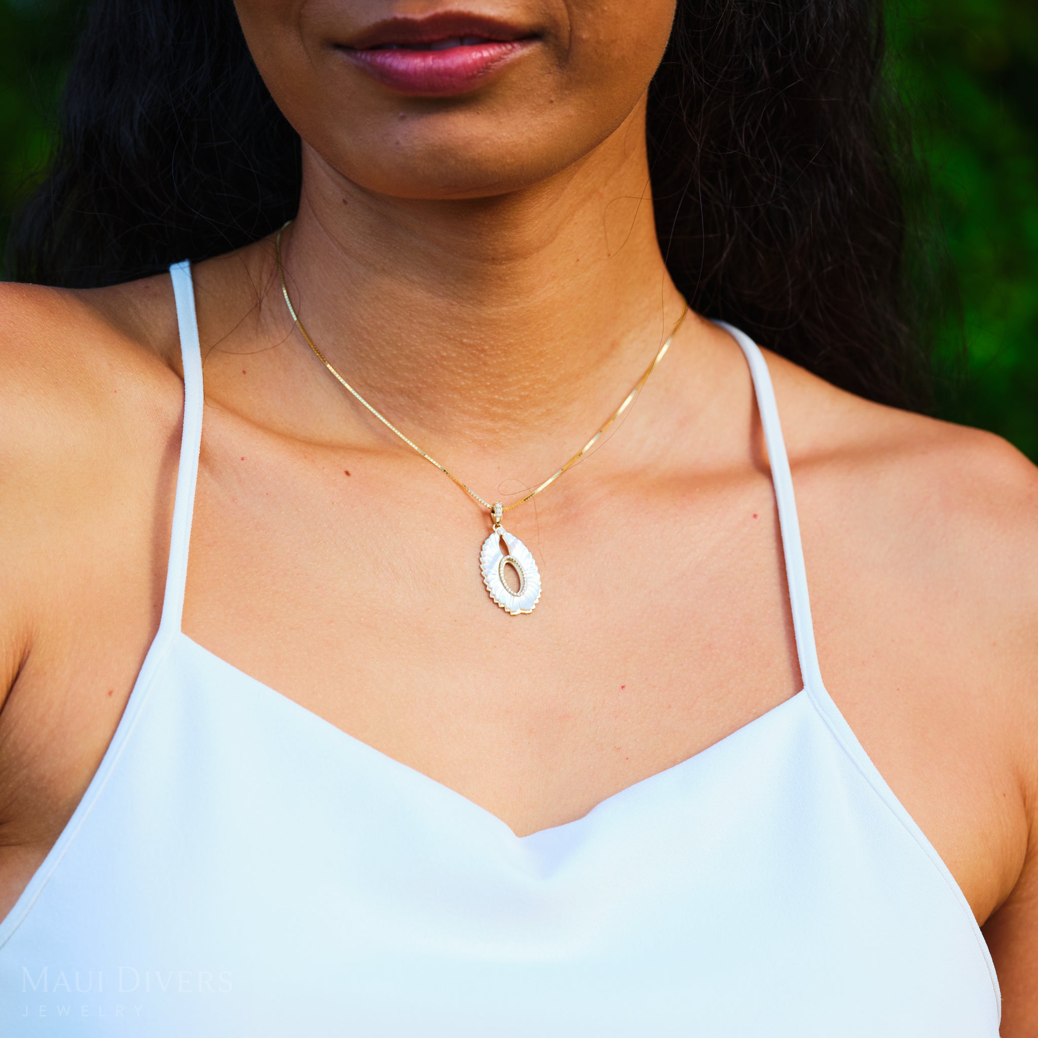 Close up of Pueo (Owl) Mother of Pearl Pendant in Gold with Diamonds on woman