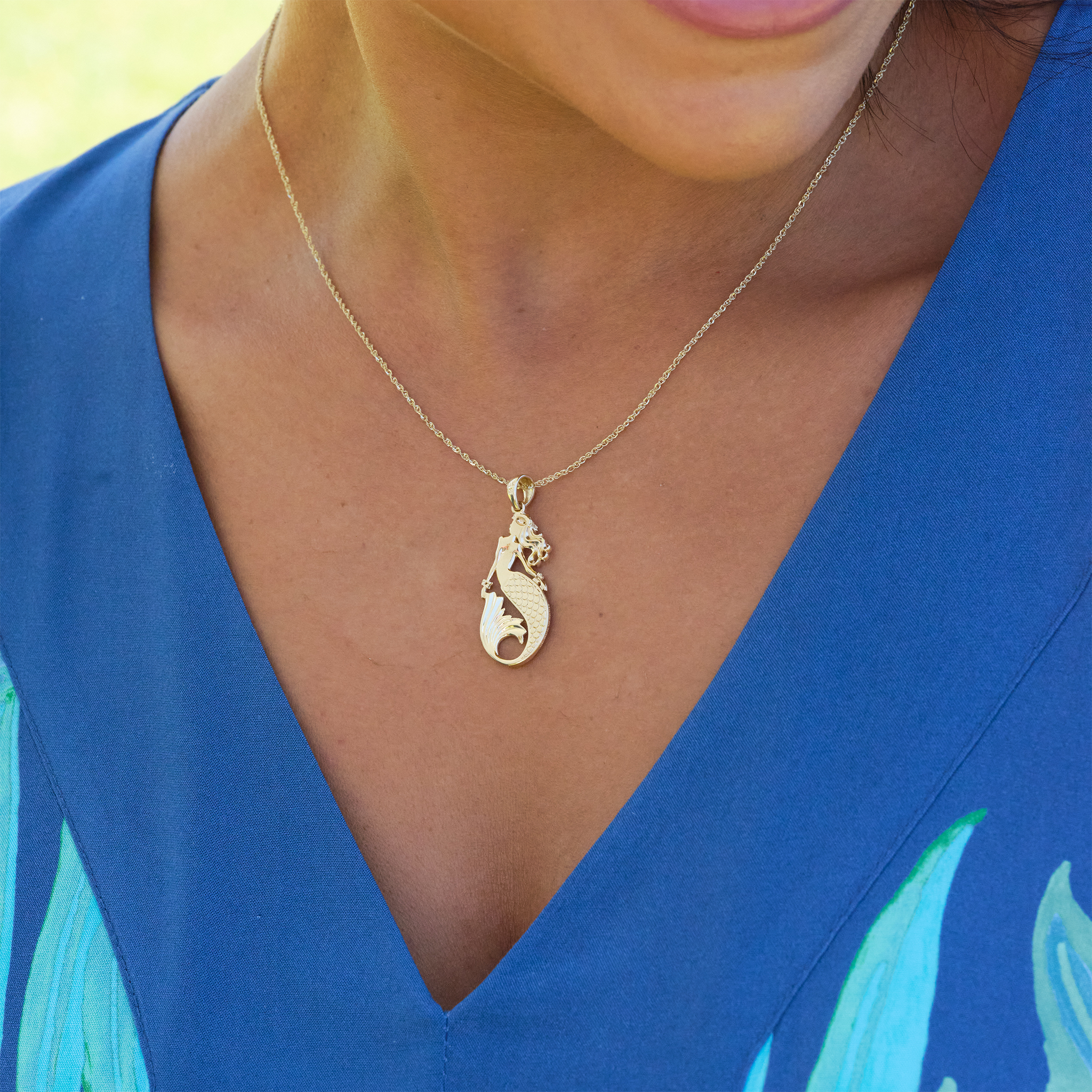A woman's chest with a Sealife Mermaid Mother of Pearl Pendant in Gold with Diamonds - 30mm - Maui Divers Jewelry
