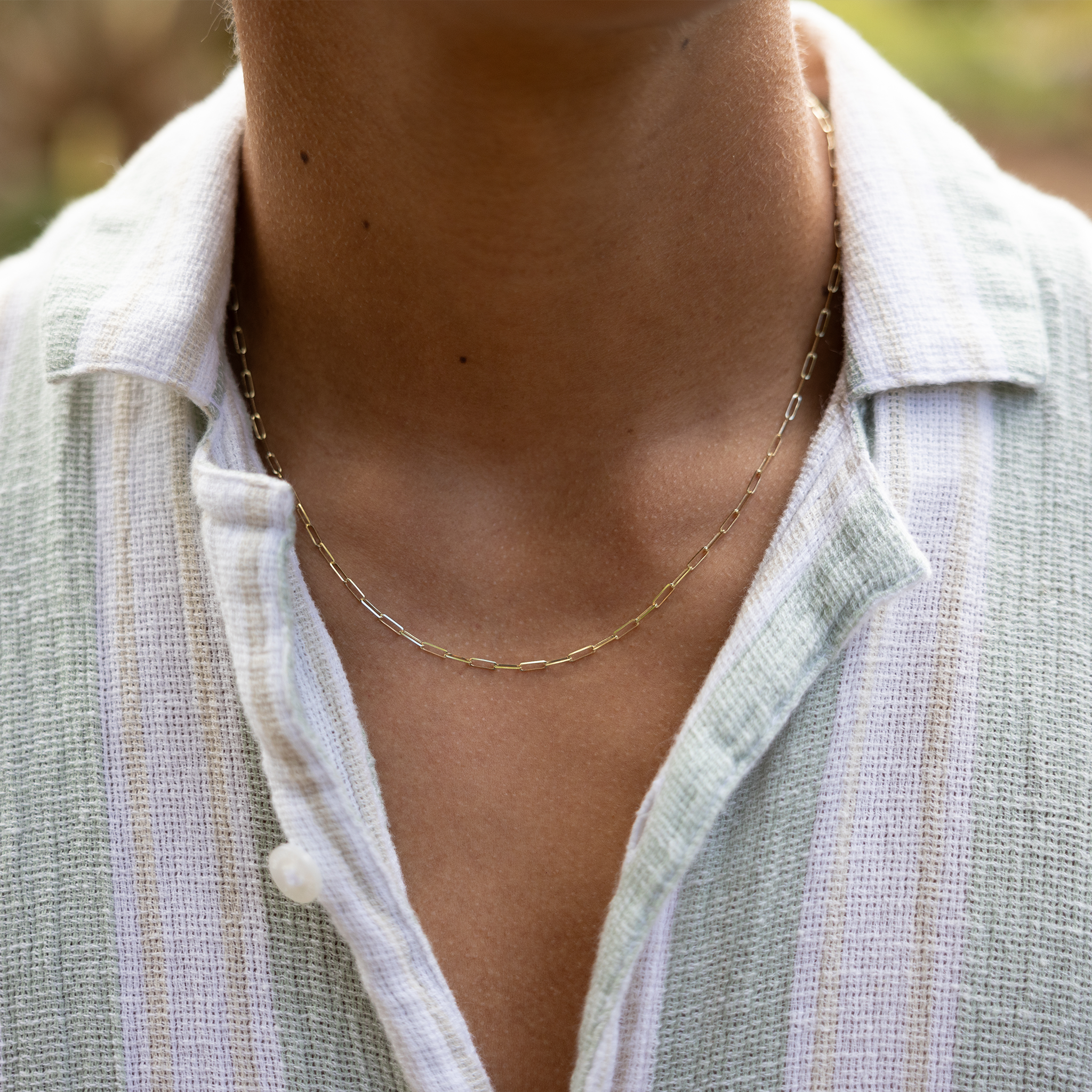 Close up of a person's neckline wearing 2mm Paperclip Chain in Gold