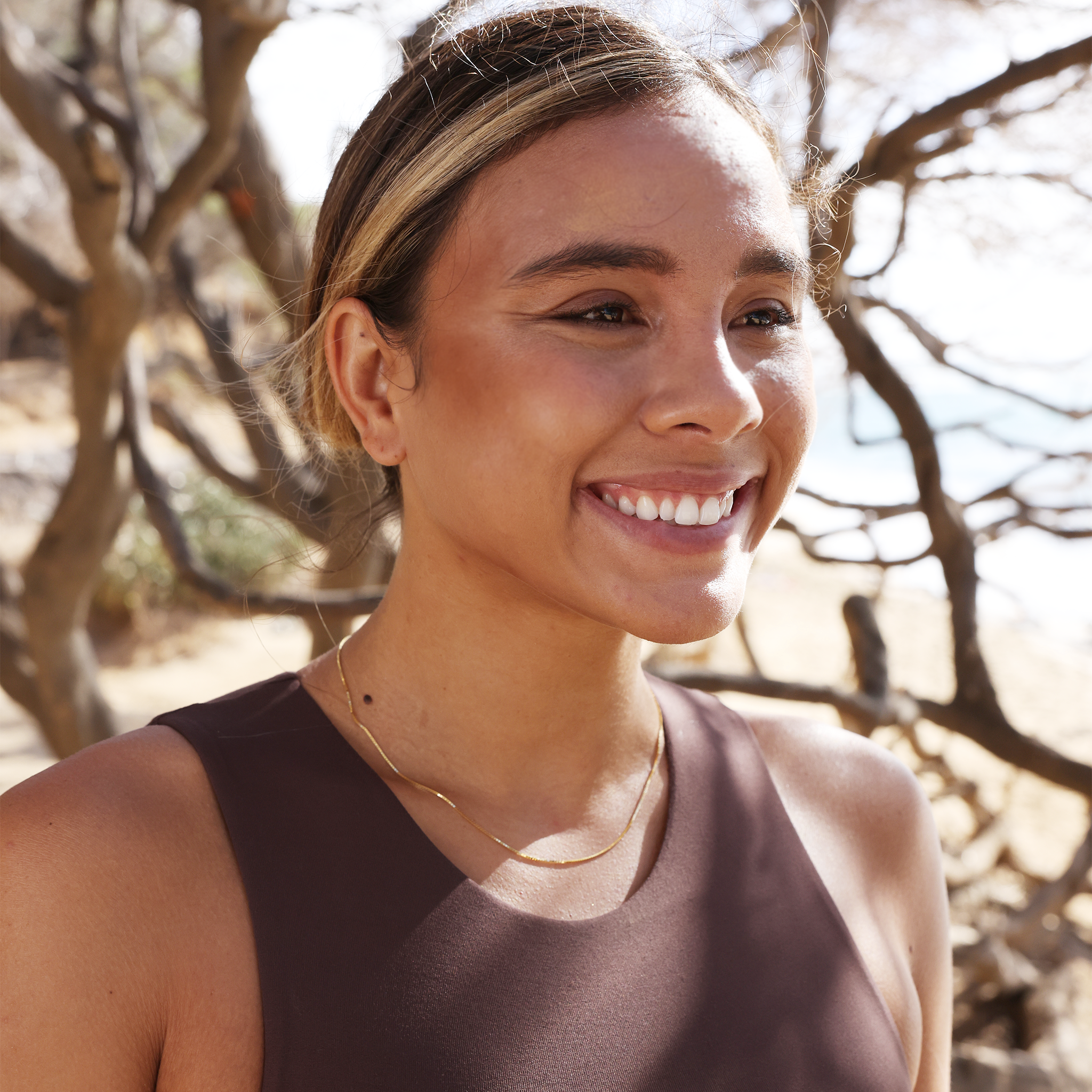 Woman outdoors wearing 0.85mm Box Chain in 14k Yellow Gold