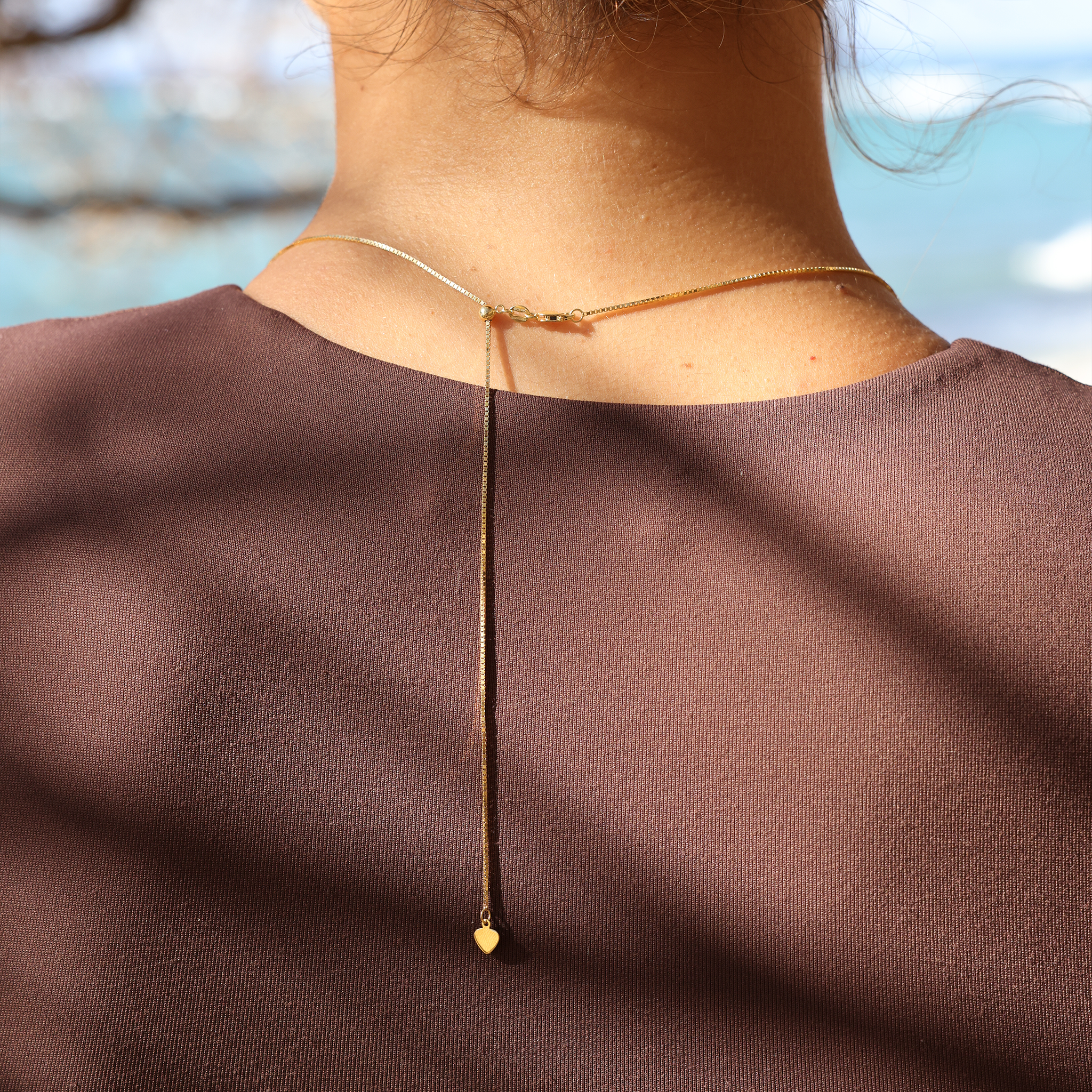 Back detail showing adjustable 0.85mm Box Chain in 14k Yellow Gold on neckline