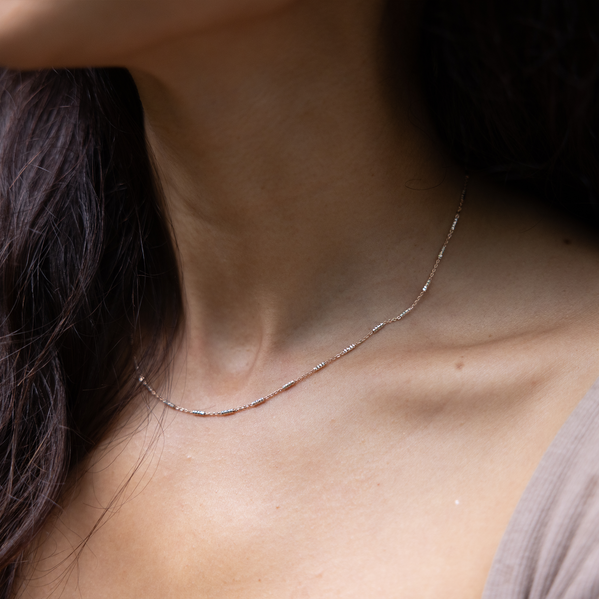 Close up of 1.0mm Tube Chain in Rose Gold and Sterling Silver on a womanʻs neck