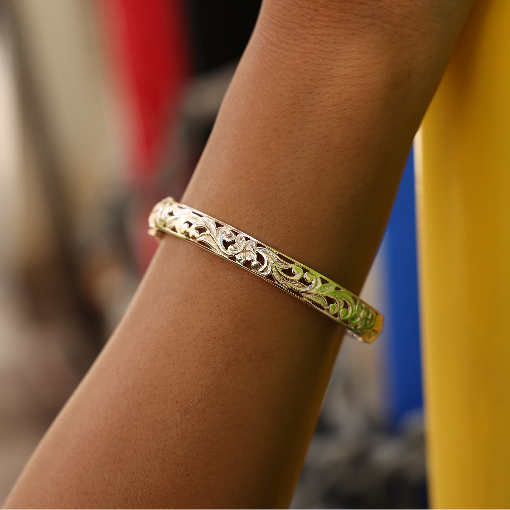 Close up of wrist wearing a Hawaiian Heirloom Plumeria Hinge Bracelet in Gold