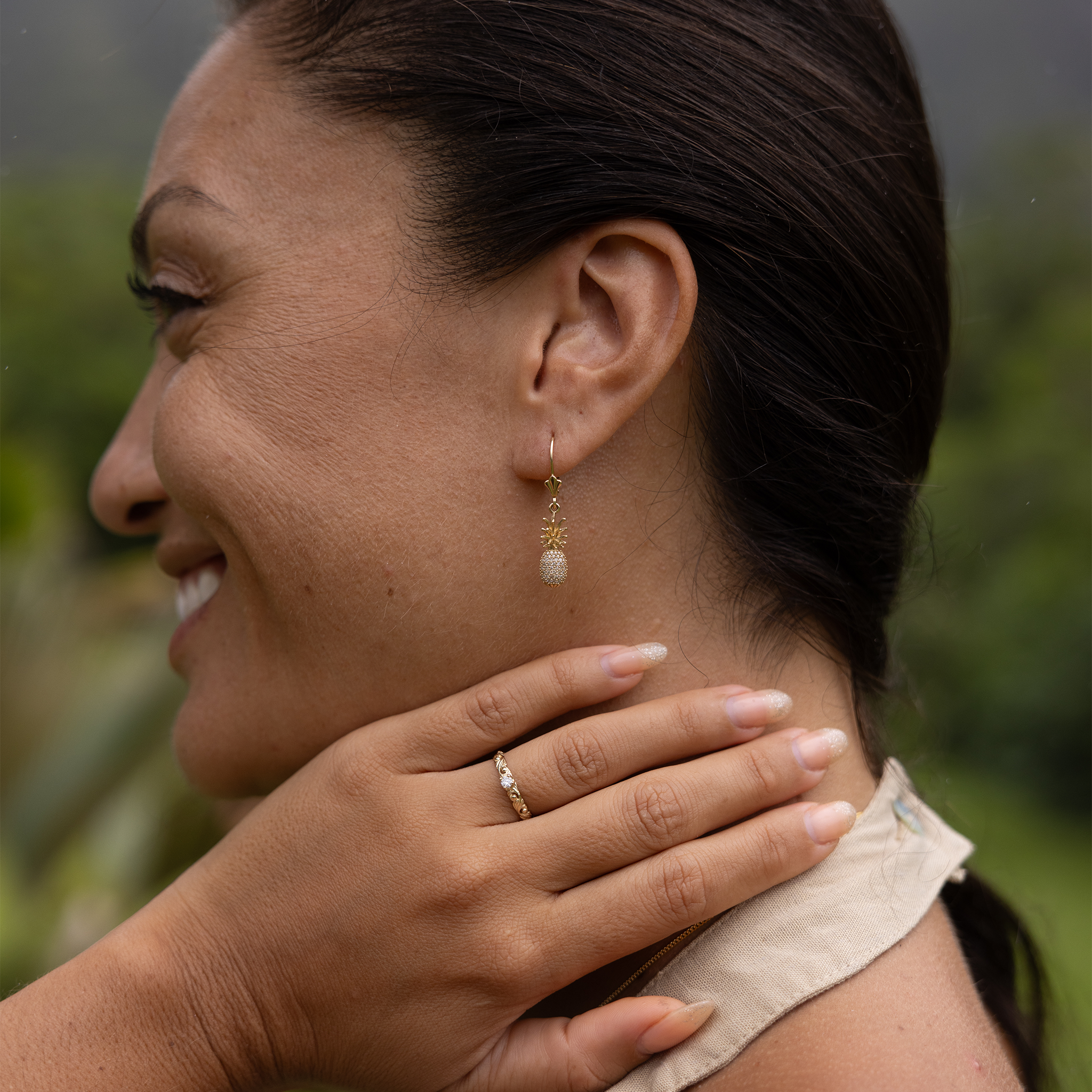 Woman in a garden wearing a Living Heirloom Ring in 14k Yellow Gold with Diamond with pineapple earrings