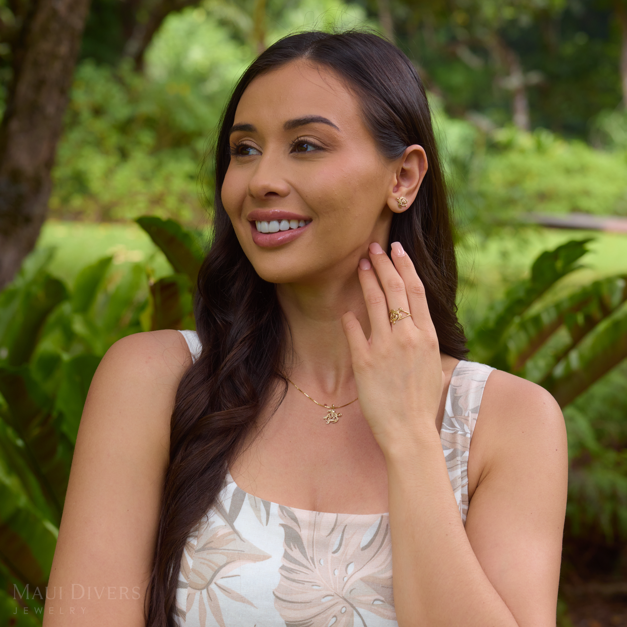 Woman in a garden wearing a Living Heirloom Honu Pendant, earring and ring in Gold