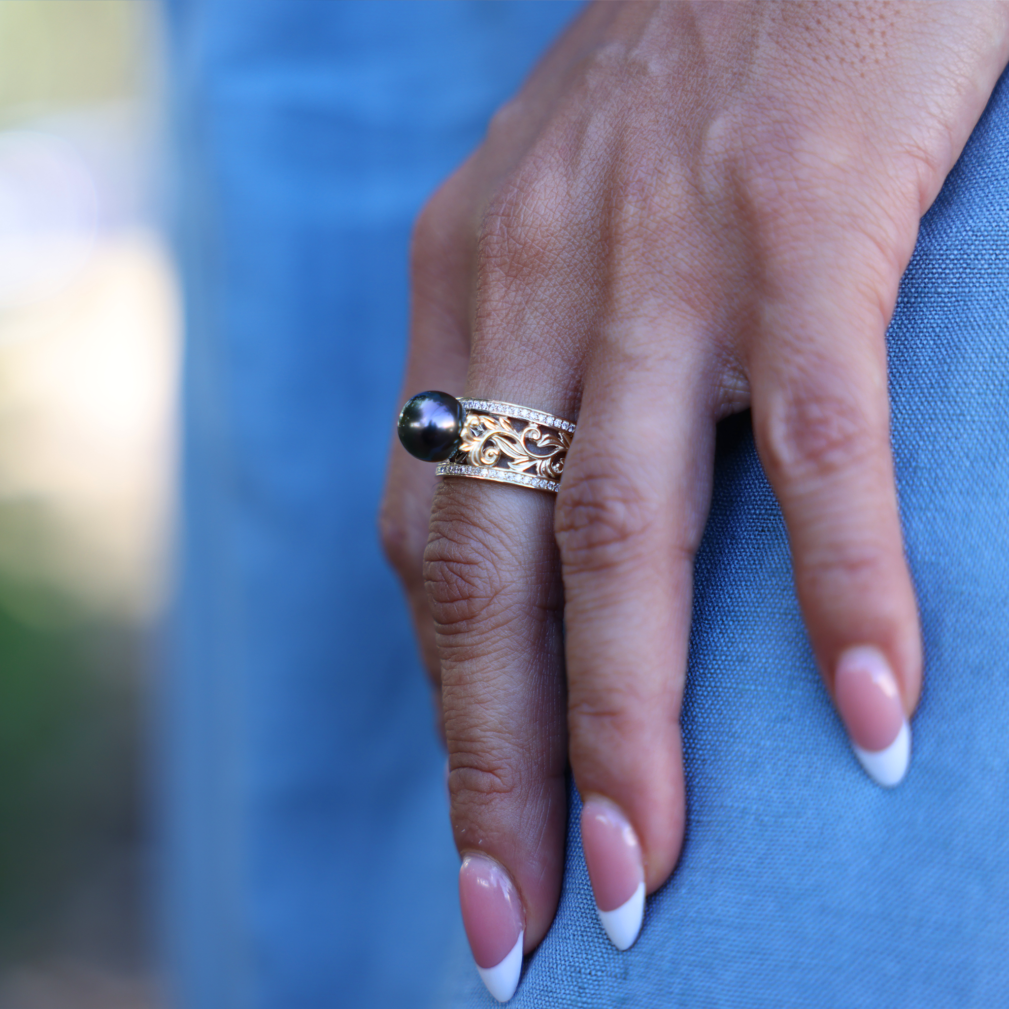 Hawaiian Heirloom Tahitian Black Pearl Ring in Gold with Diamonds on Hand over blue dress