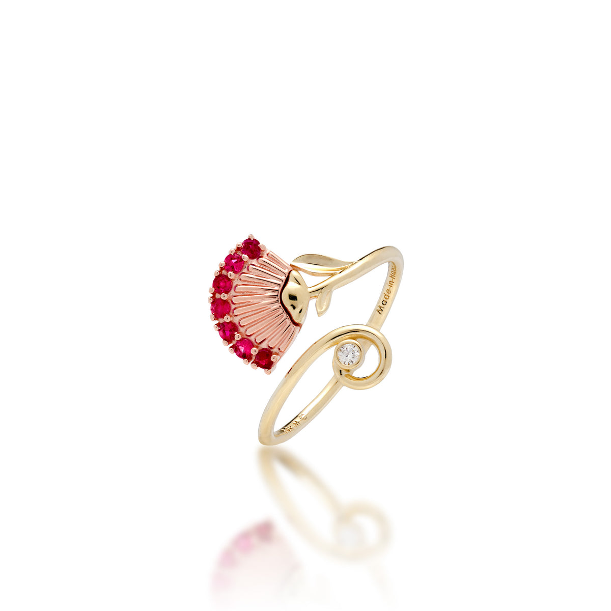 An ʻŌhiʻa Lehua Flower Ring with a 14k Rose gold flower set with red rubies and a high-polish 14k yellow gol dband with a curling end set with a diamond, shown on a white background