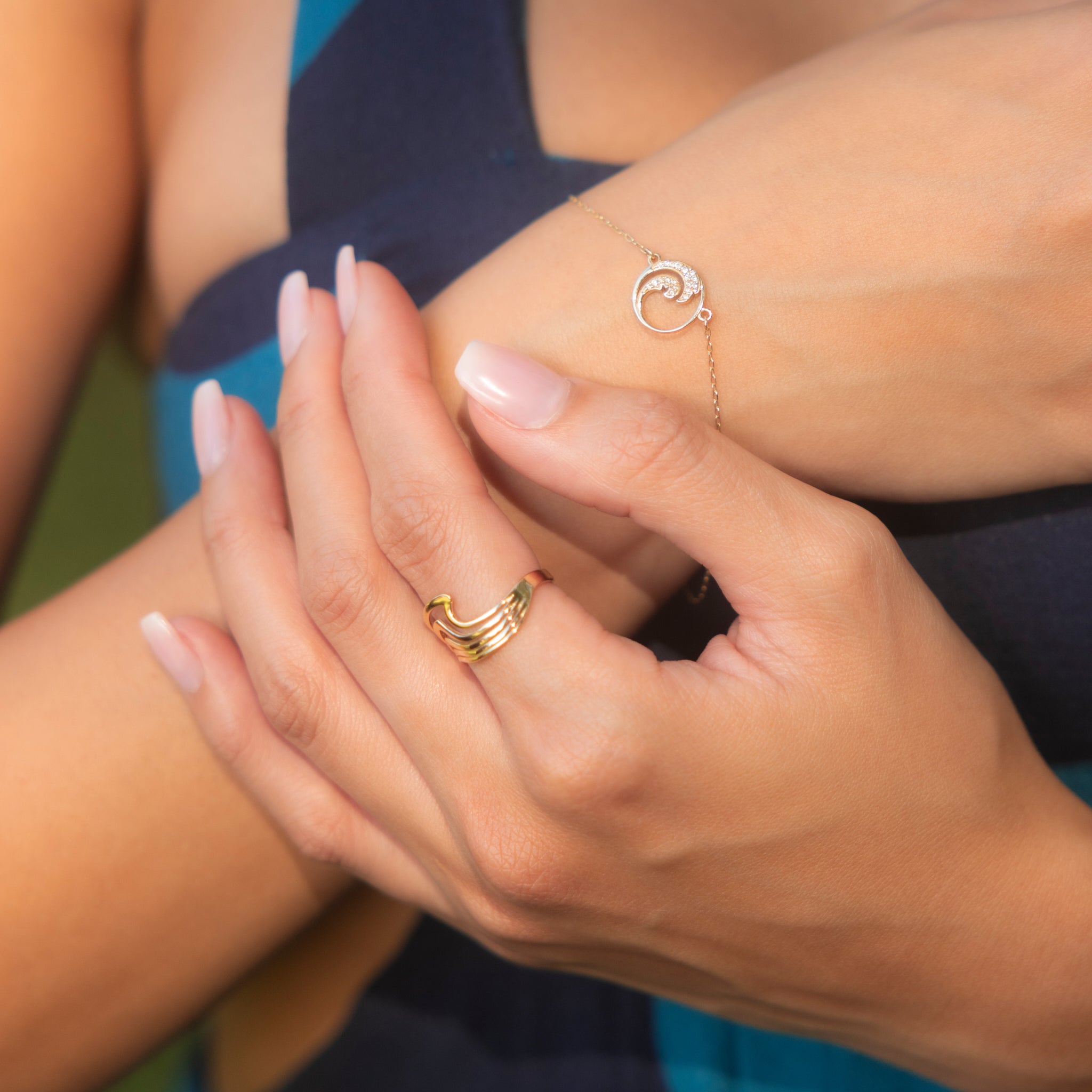 Close up of an Abstract Nalu Ring and Diamond Nalu Bracelet on a woman's arms