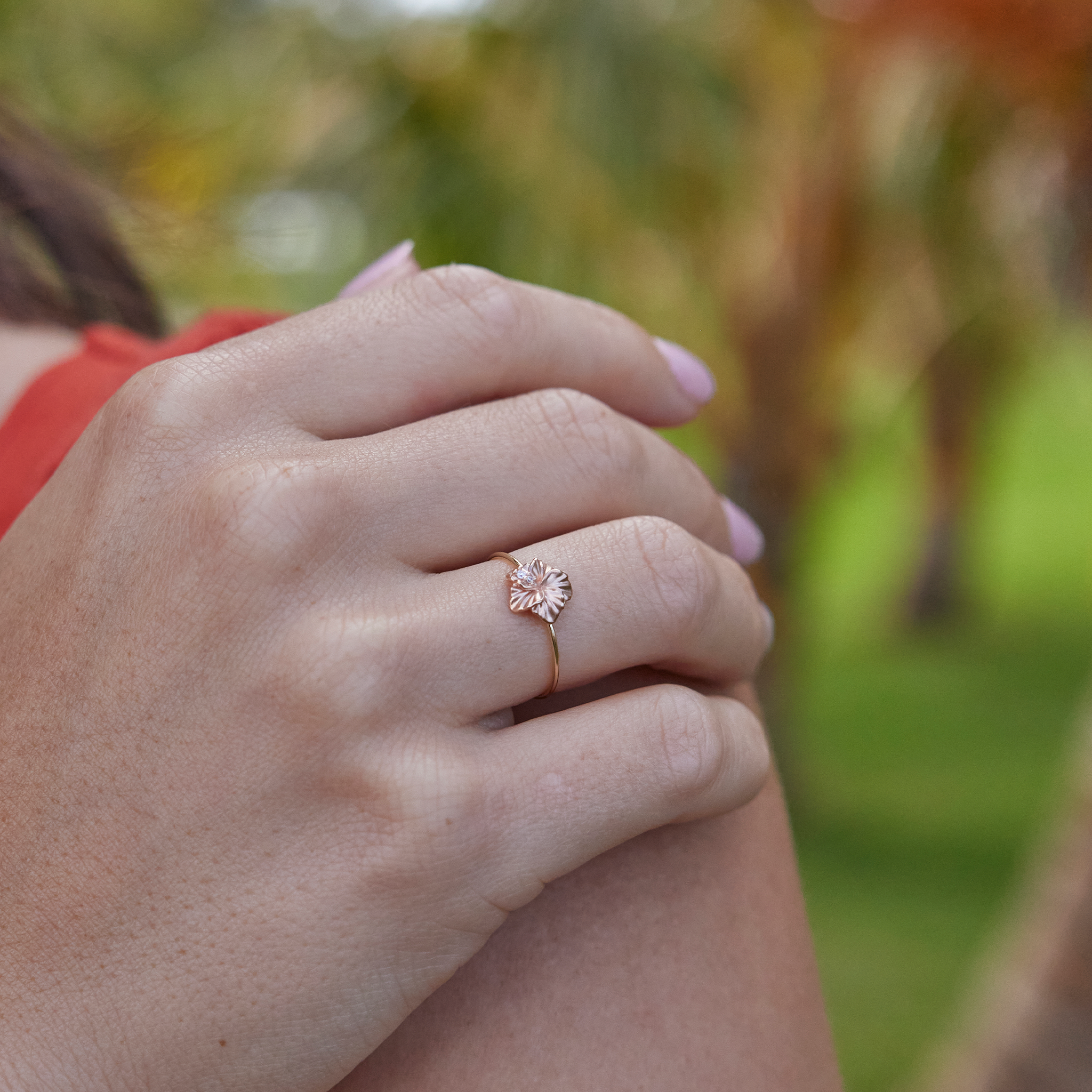 Close up of an 8mm Hawaiian Gardens Hibiscus Ring in Two Tone Gold with Diamonds with blurred background