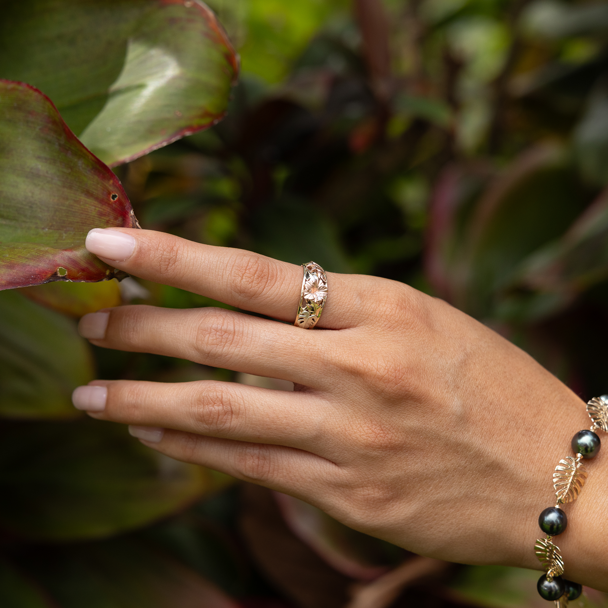 Hawaiian Gardens Hibiscus Ring in 14k Yellow, Rose, and Green Gold with Diamonds on hand in a garden