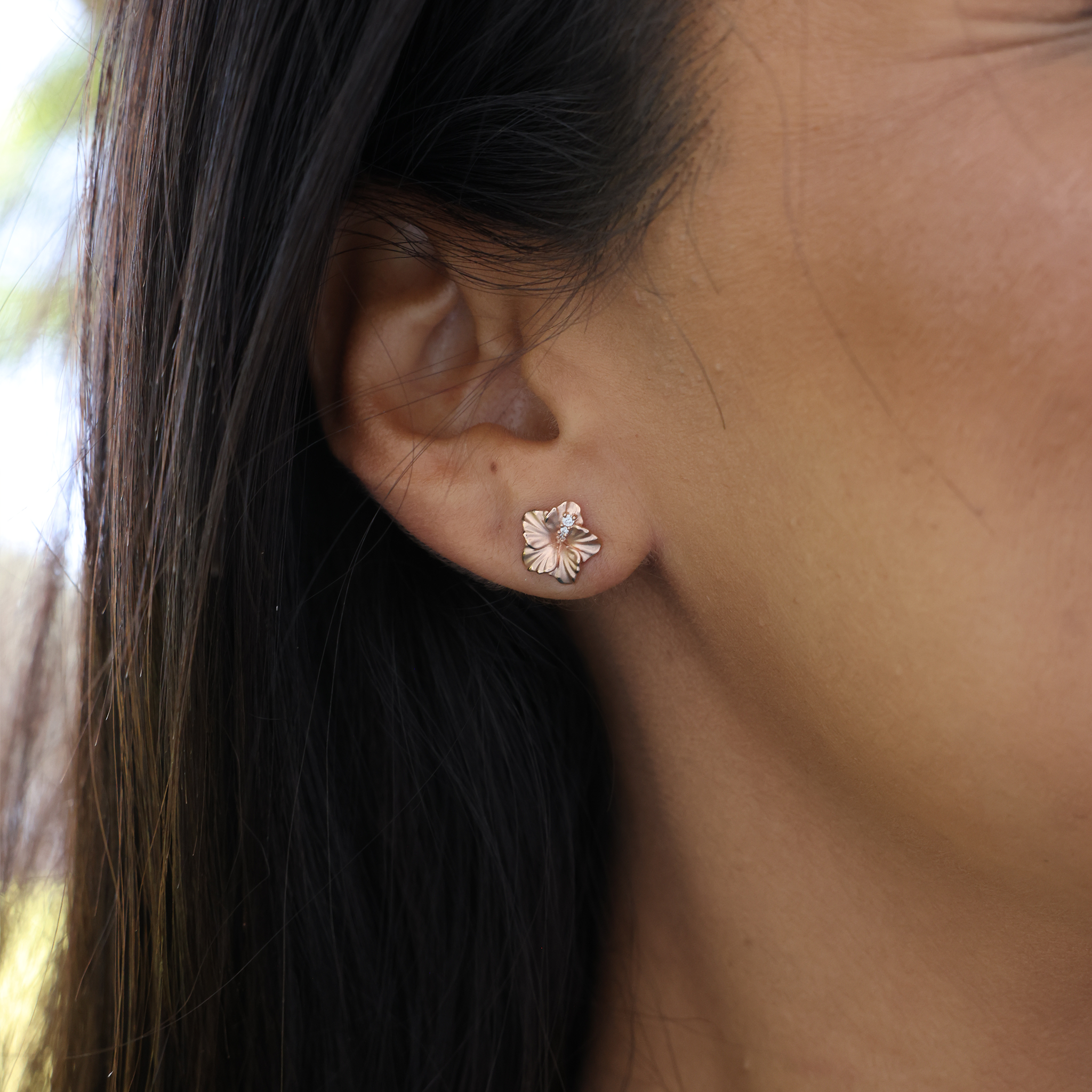 Close up of 9.5mm Diamond Hibiscus Earrings in 14k Rose Gold on ear