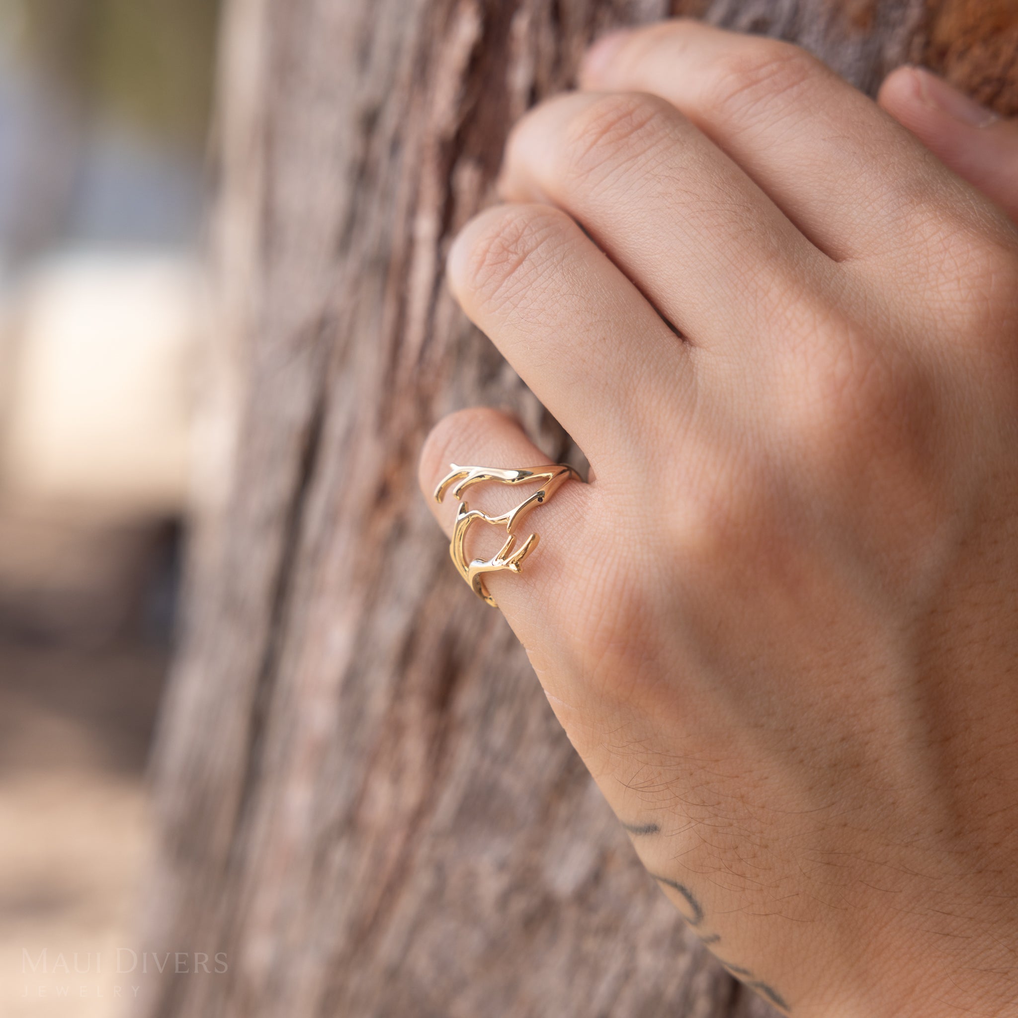 Heritage Coral Branch Ring in Gold on a hand against a tree background