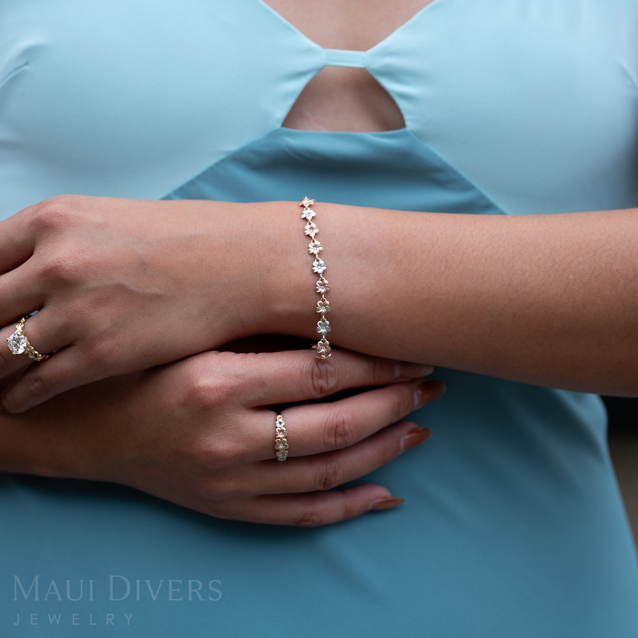 Close up of 7-8.5" Adjustable Plumeria Bracelet in Tri Color Gold with Diamonds and matching ring on arms