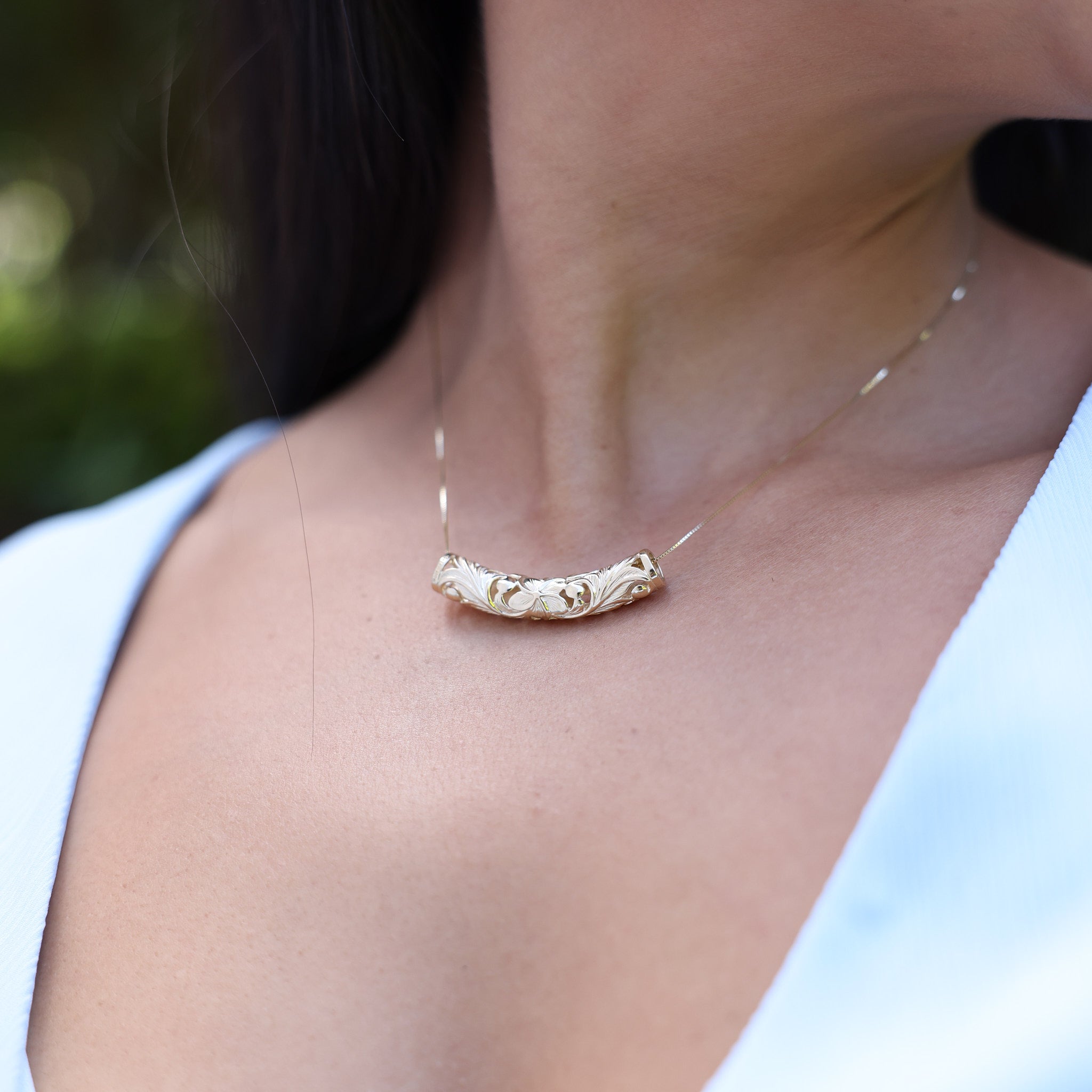 Close up of Hawaiian Heirloom Plumeria Barrel Pendant in Gold - 37mm on model