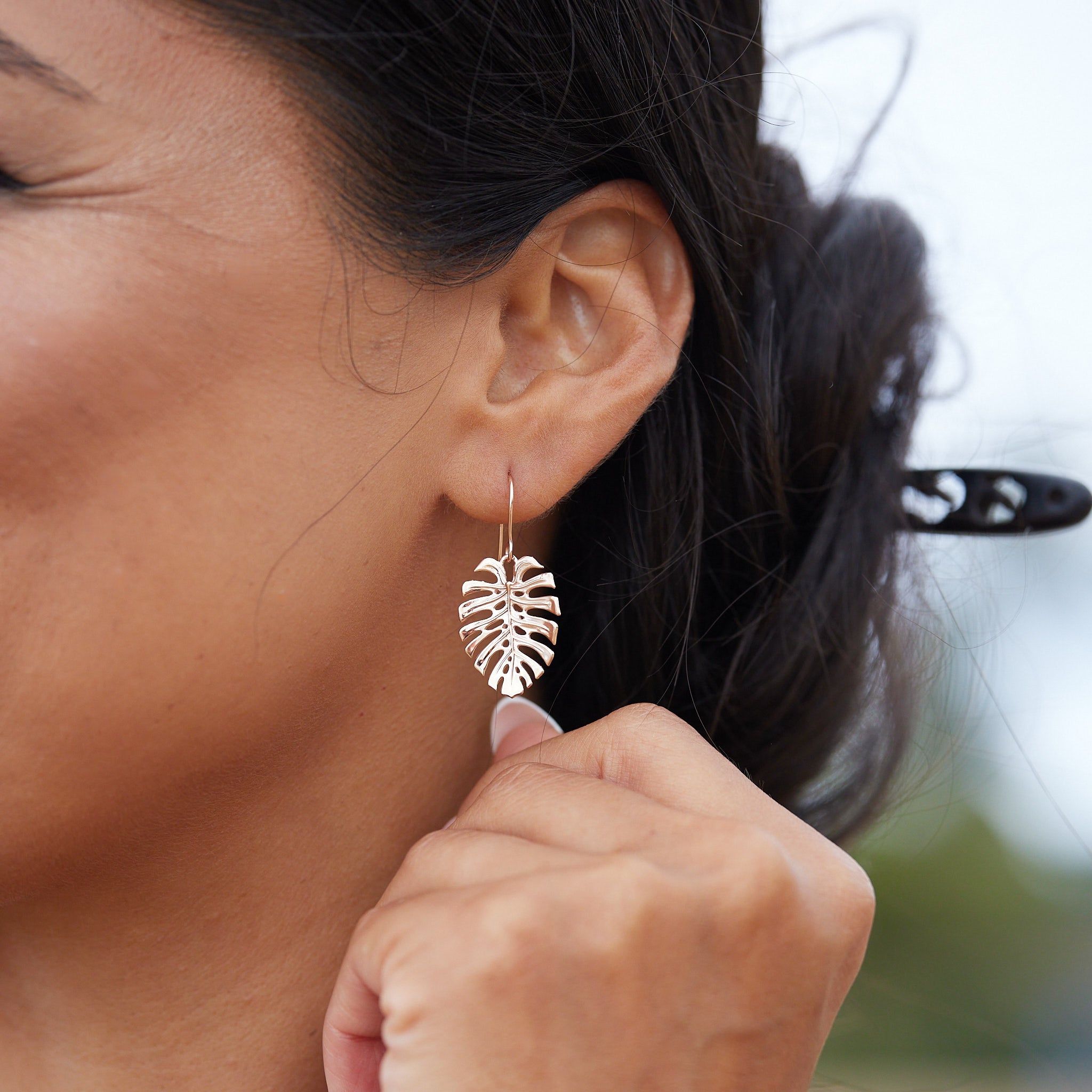 A woman's ear with Monstera Earrings in Rose Gold - 23mm - Maui Divers Jewelry