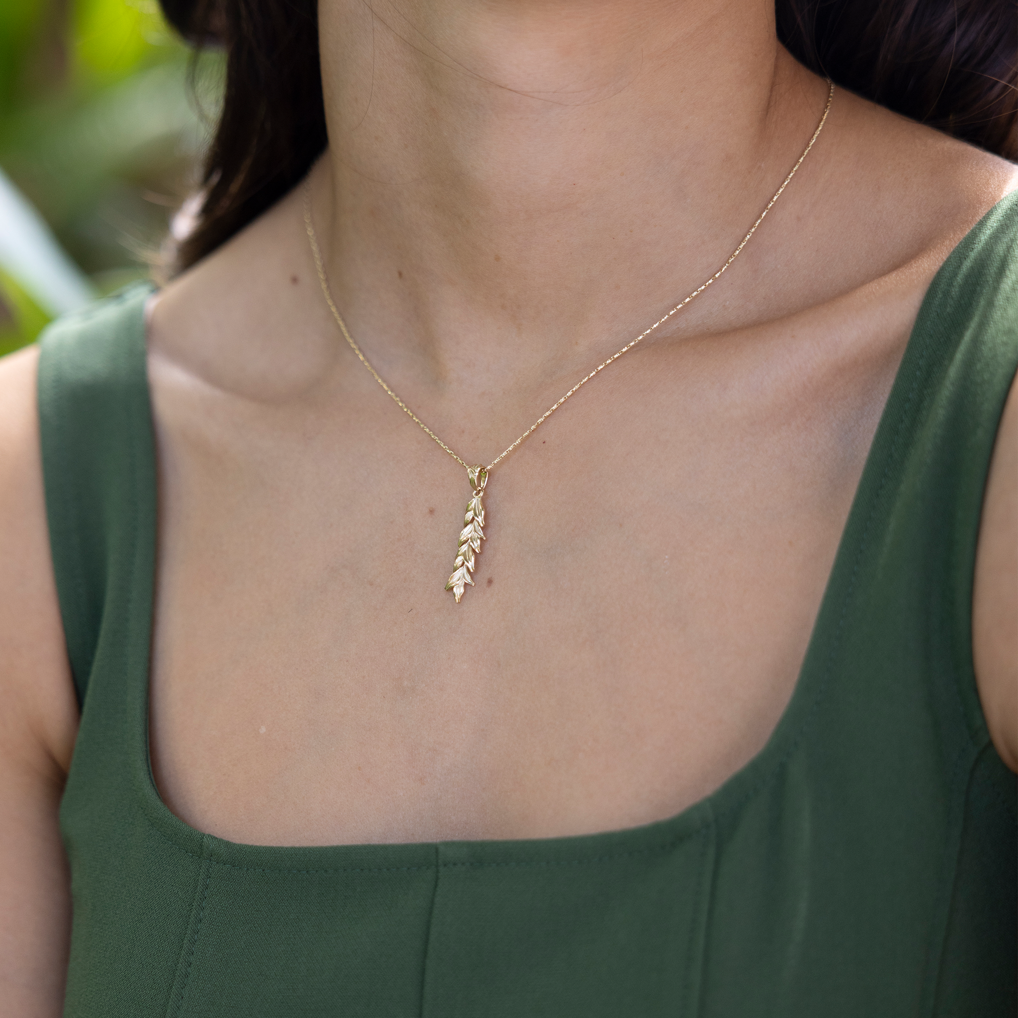 Close up of a 35mm Maile Pendant in Gold on a woman's chest