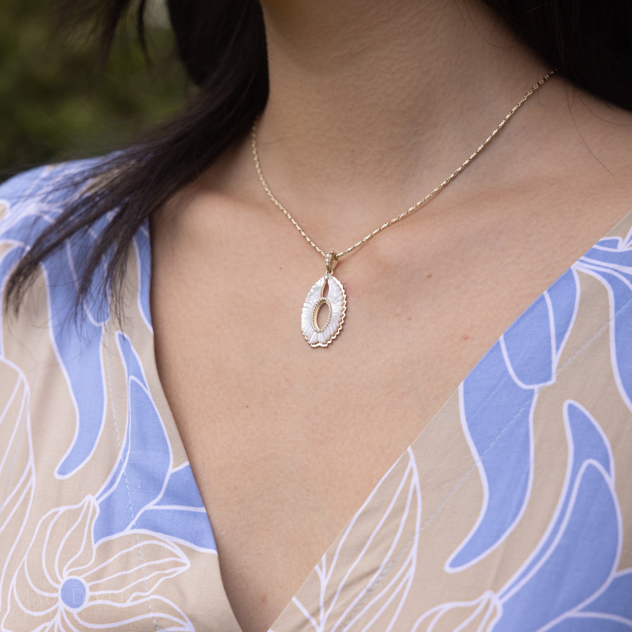 Close up of Pueo (Owl) Mother of Pearl Pendant in Gold with Diamonds on woman