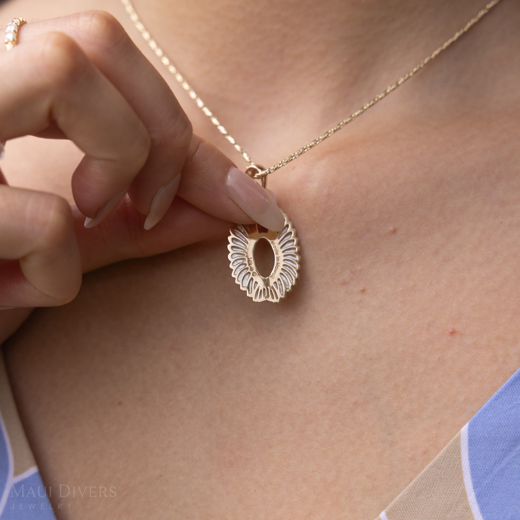 Backside detail of Pueo (Owl) Mother of Pearl Pendant in Gold with Diamonds held by woman