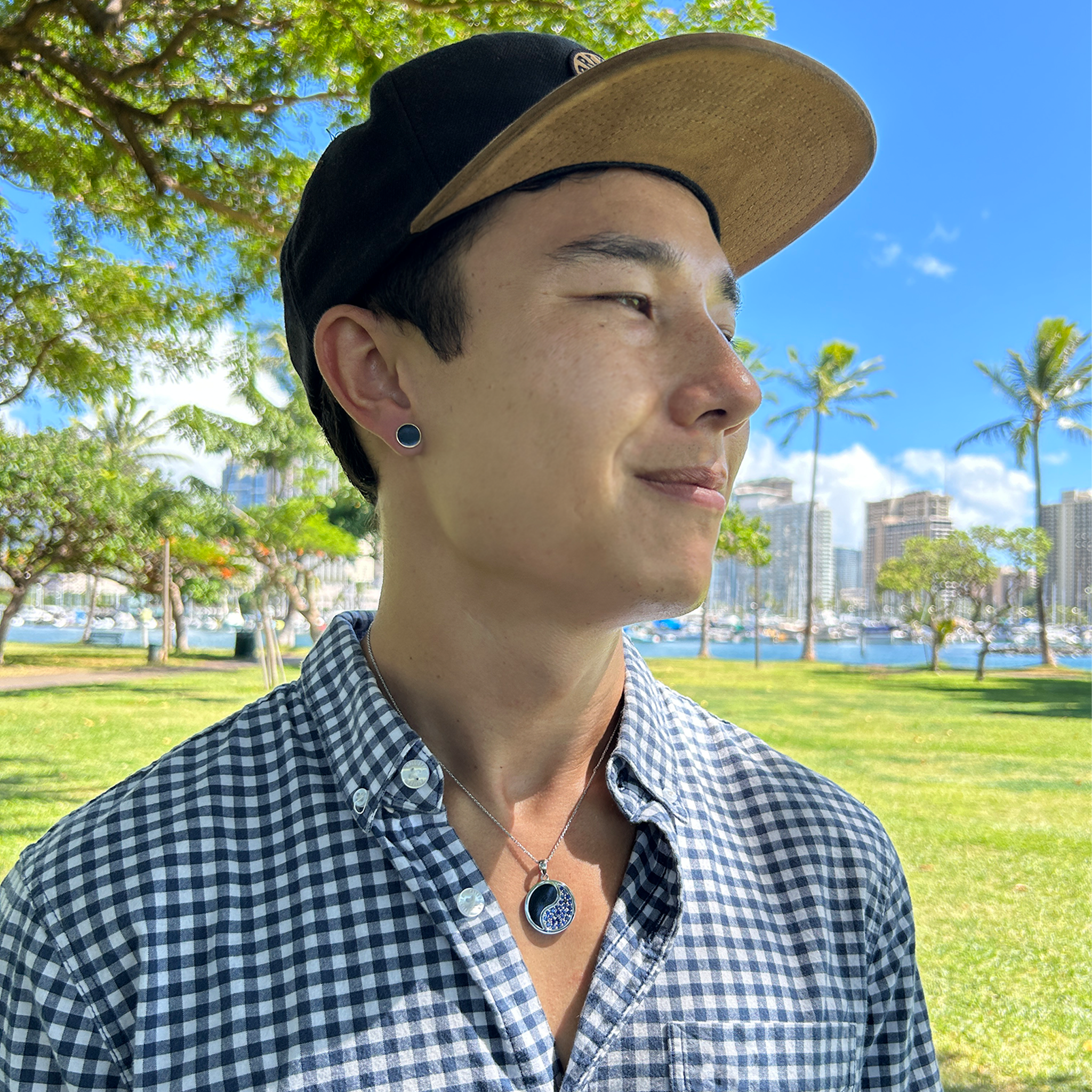 Man in a beach park wearing 1.0mm Rope Chain in 14k White Gold and a Yin Yang pendant