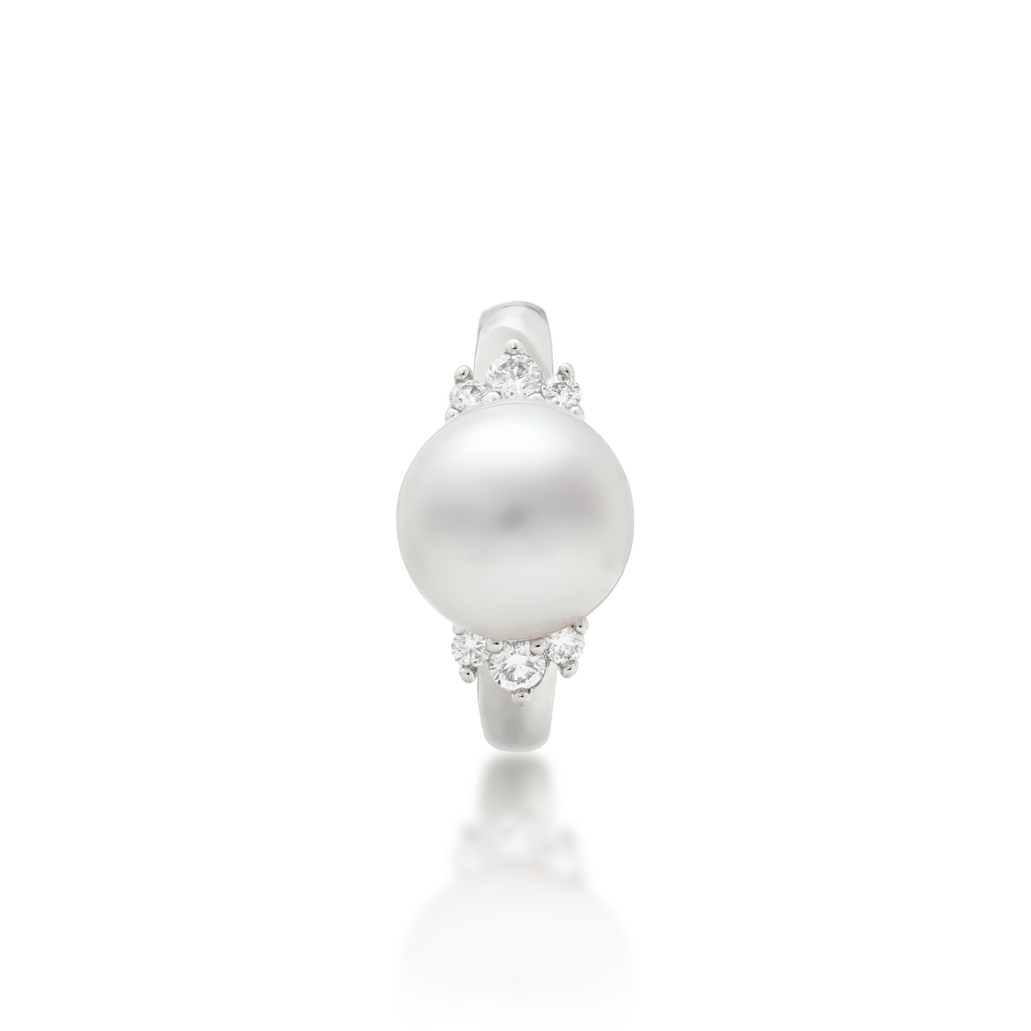 Top view of a 14k white gold ring featuring a large, lustrous South Sea White pearl as the center stone, accented by three diamonds on either side of the band, set against a clean white background with a soft reflection below.