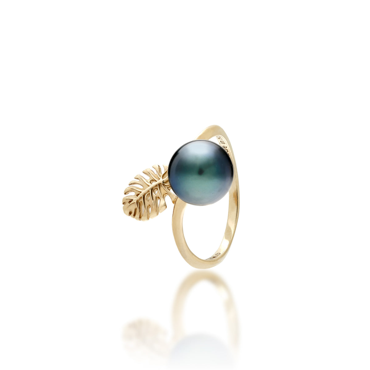 A 14k gold ring featuring a 8-9mm Tahitian Black pearl with a small cutout monstera leaf detail shown on a white background.
on a white background