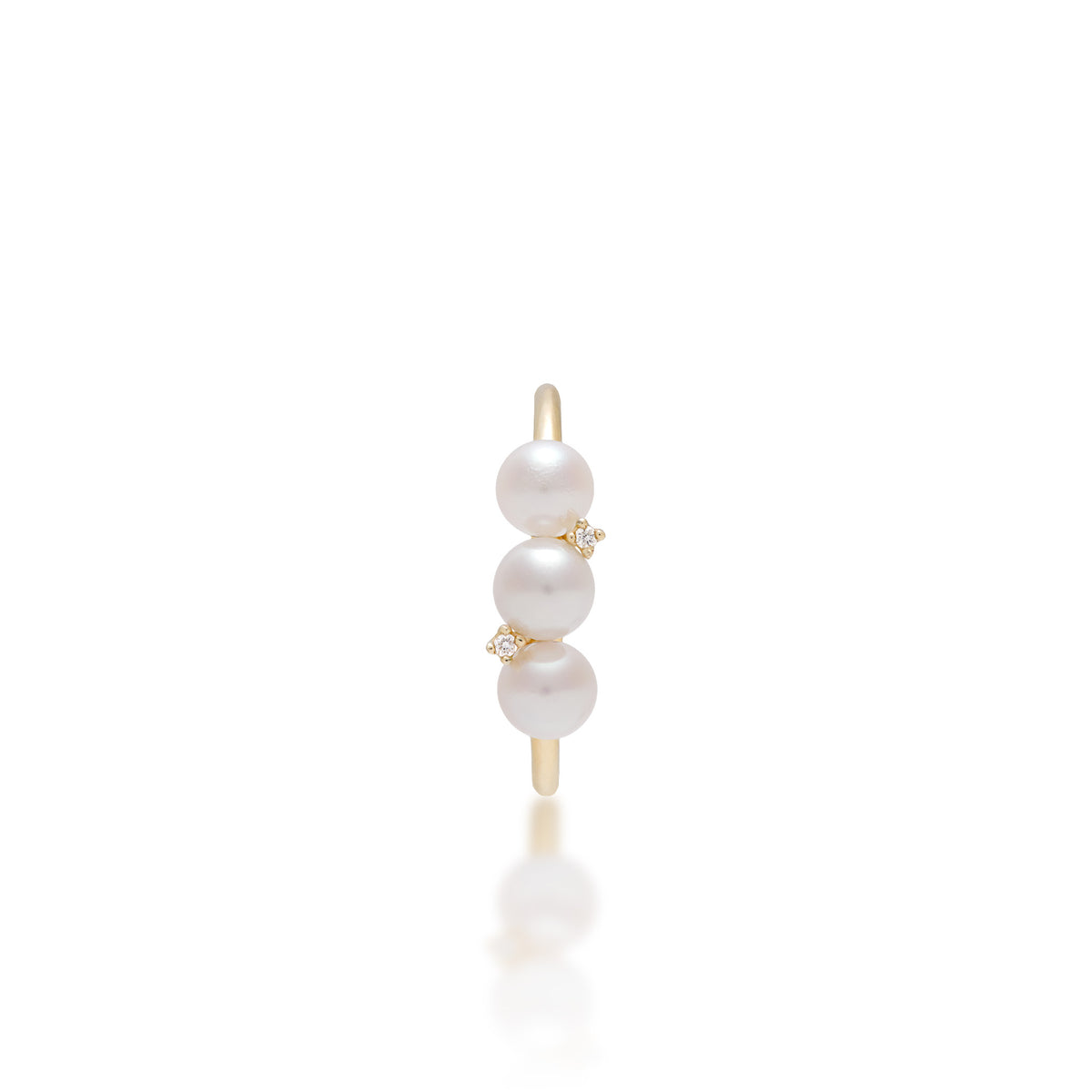 A 14k yellow ring featuring three vertically aligned Akoya white pearls with an alternating natural diamond in between the center pearls, shown on a reflective white surface.