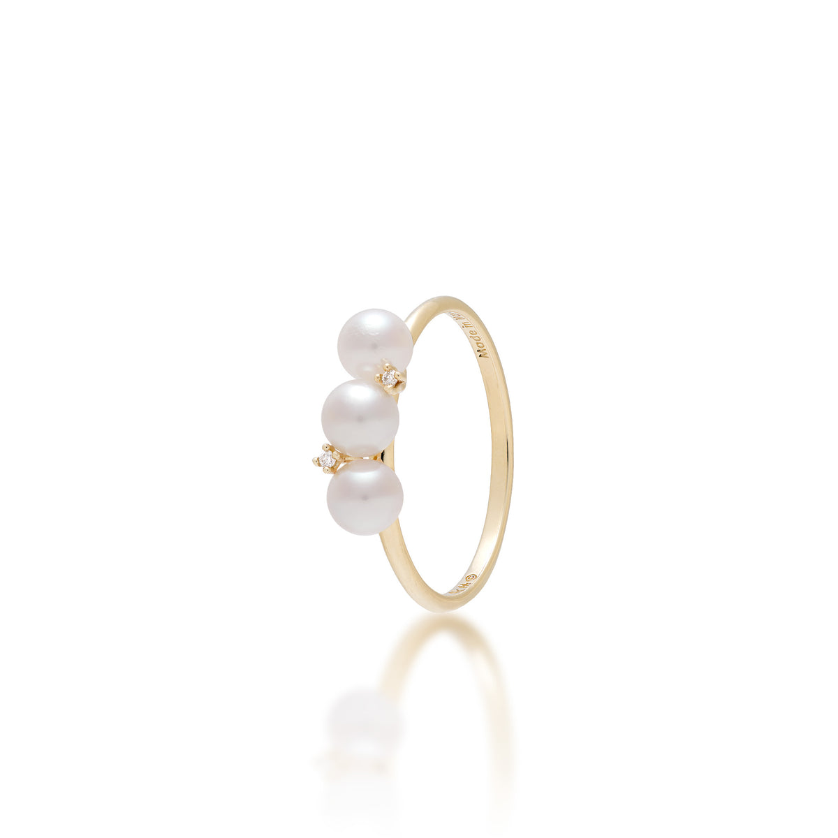 A 14k yellow ring featuring three vertically aligned Akoya white pearls with an alternating natural diamond in between the center pearls, shown on a reflective white surface.