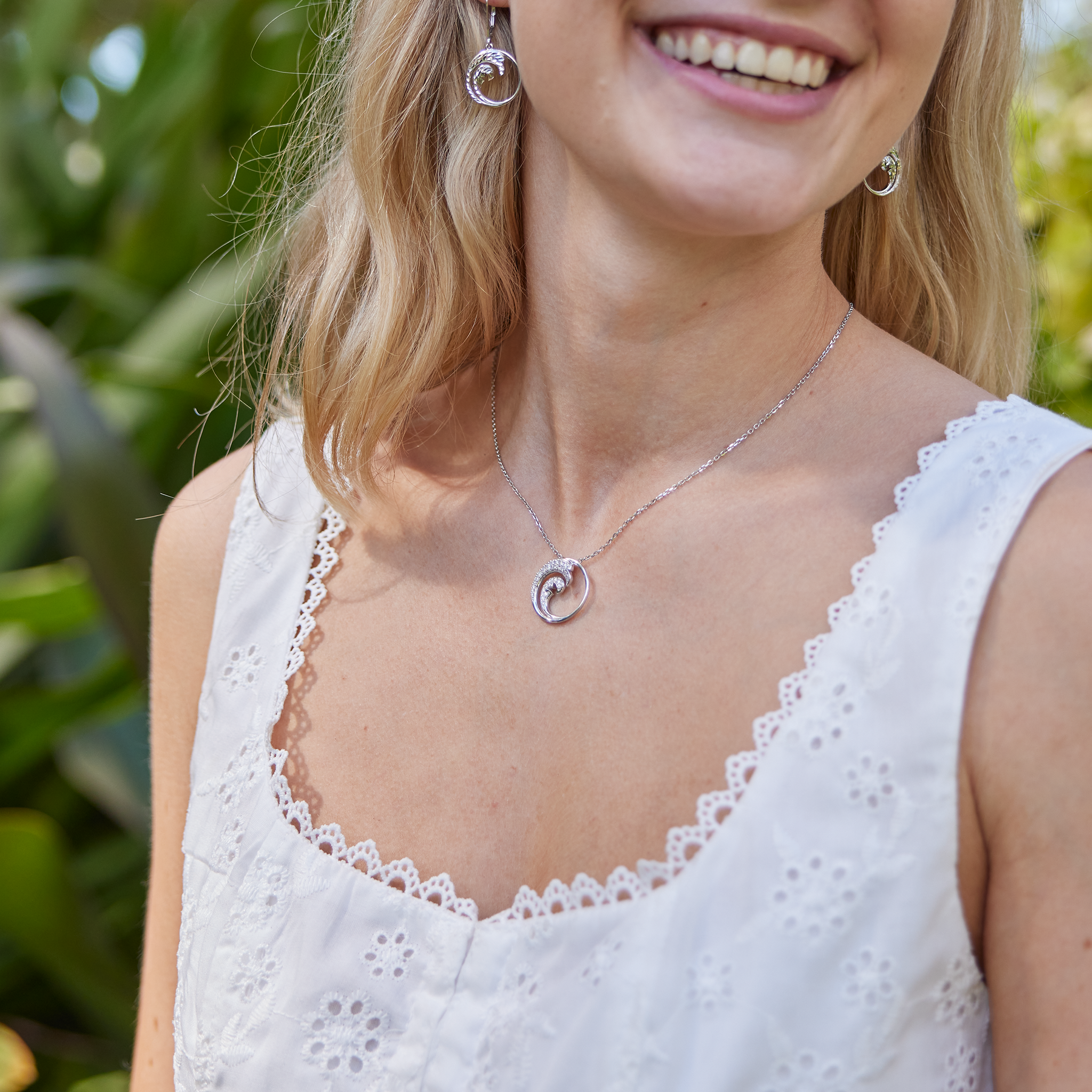 Woman in garden wearing Nalu Pendant in White Gold with Diamonds - 22mm
