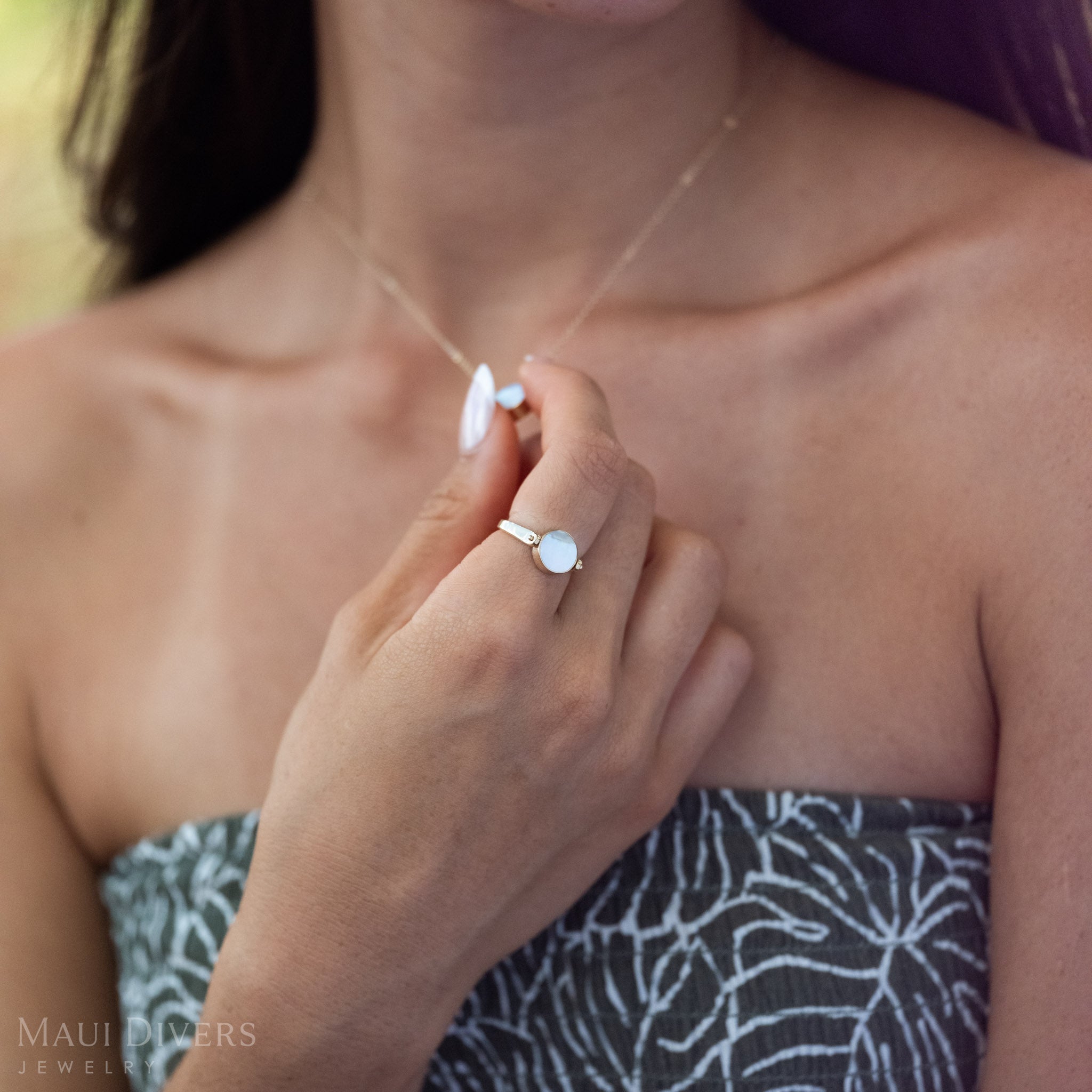 Close-up of the Eclipse ring in 14k Gold showing the Mother of Pearl Side and the matching necklace. 