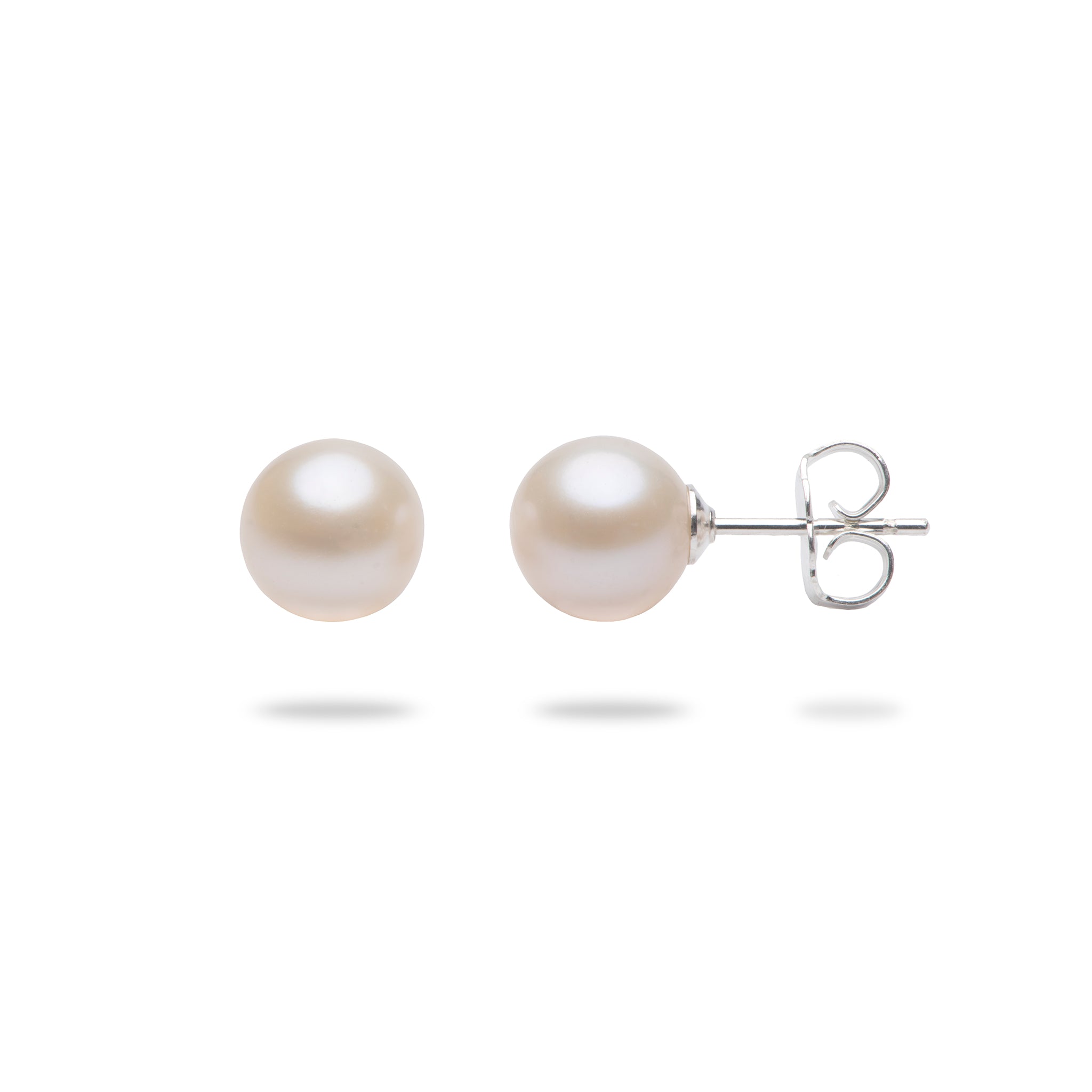 A pair of classic stud earrings featuring round, lustrous white freshwater pearls set in polished sterling silver posts with butterfly backings, shown against a clean white background.