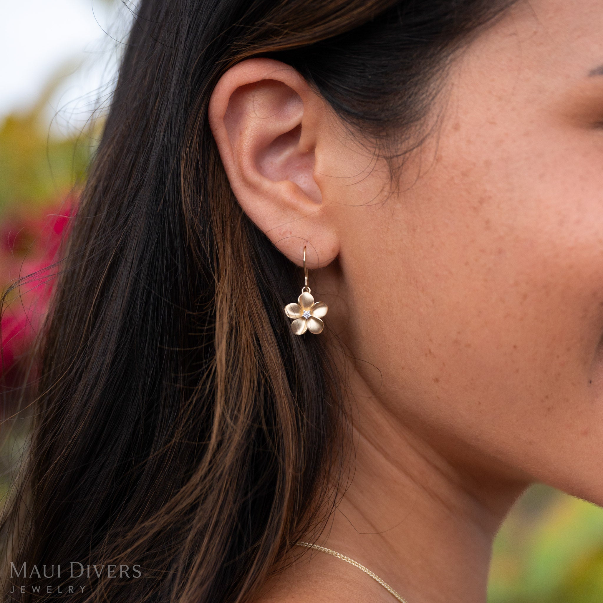 Close-up shot of 14k Gold Plumeria Earring with Natural Diamond Center. 