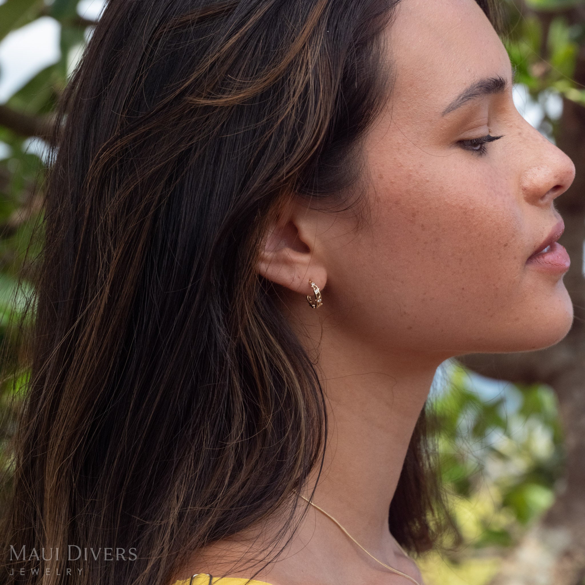 Woman's side-profile wearing Heritage Earrings in 14k Gold with Natural Diamonds.