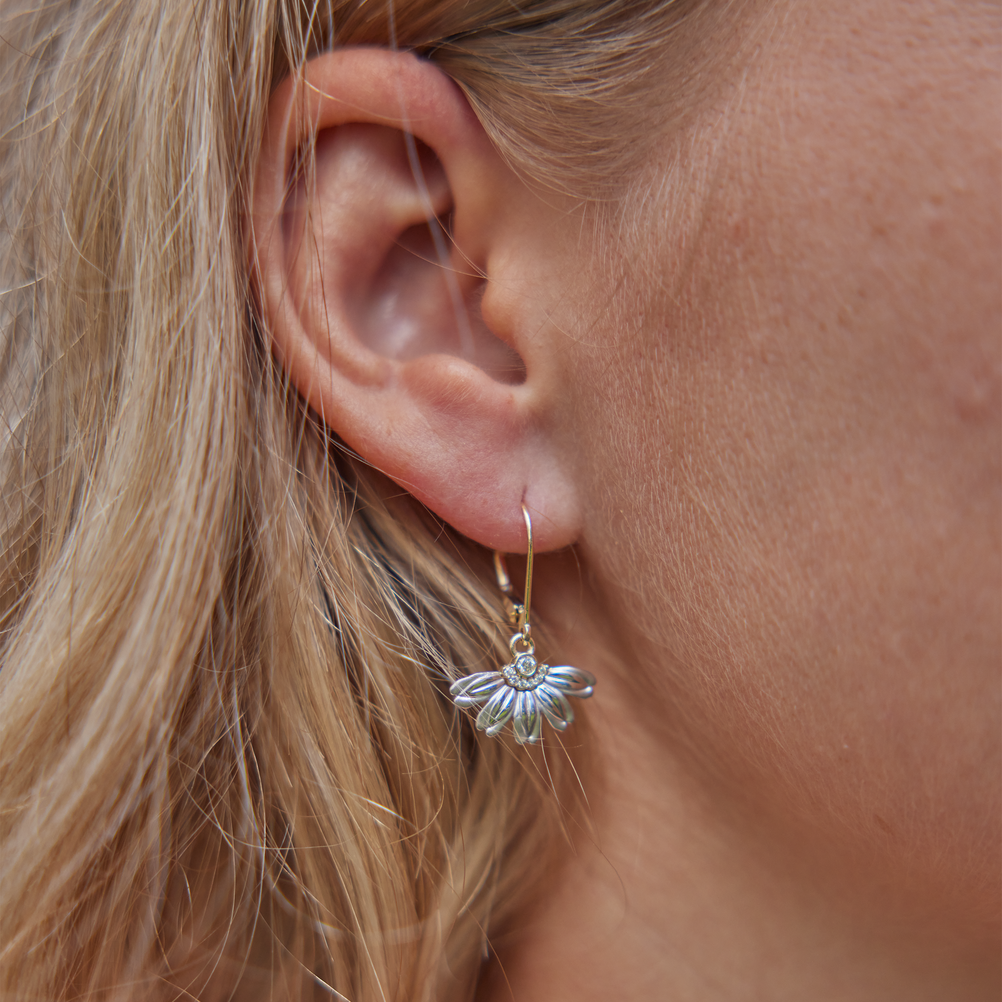 Close of of ear wearing Beach Naupaka Earrings in Two Tone Gold with Diamonds