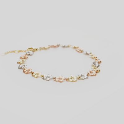 7-8.5" Adjustable Plumeria Bracelet in Tri Color Gold with Diamonds on a white turntable