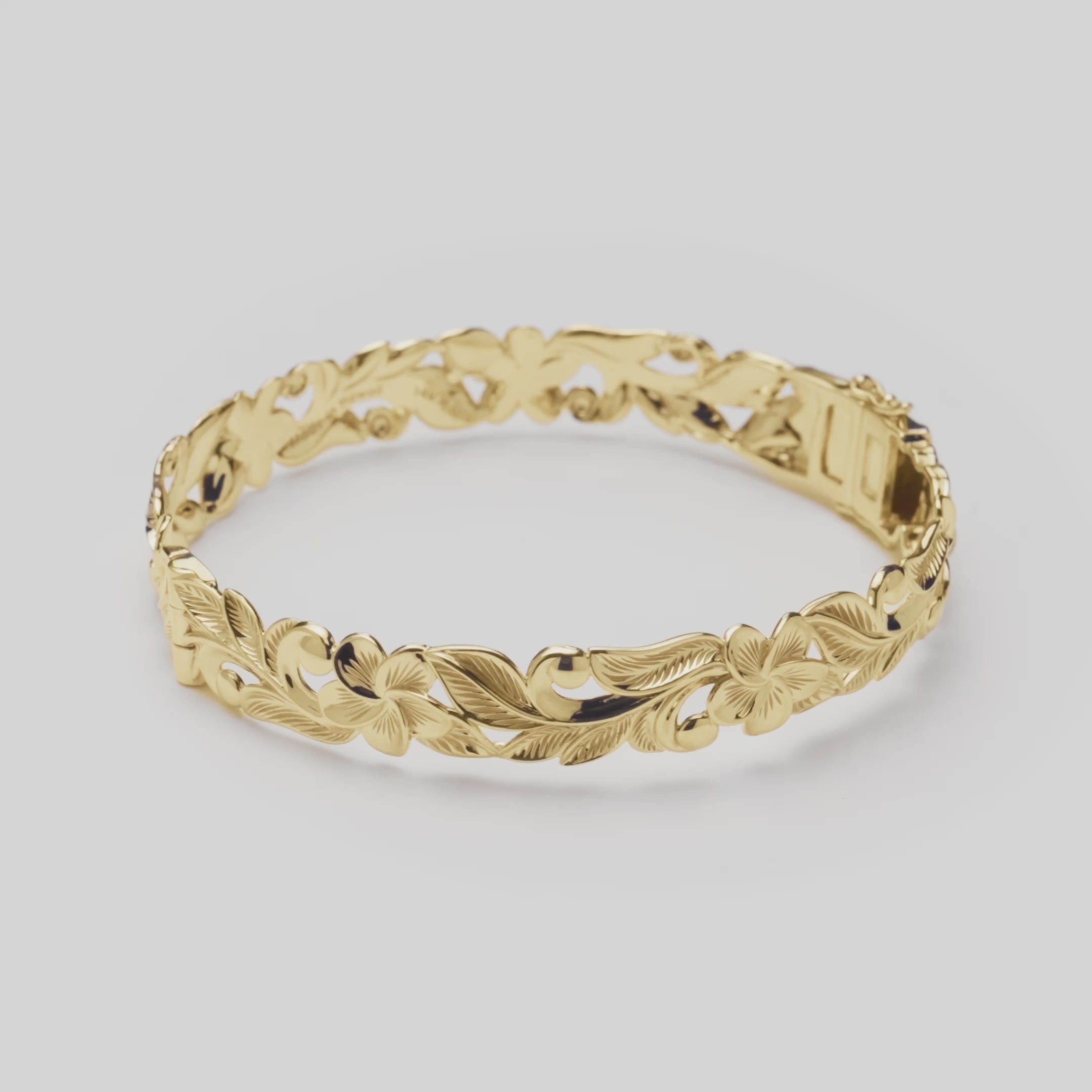 Hawaiian Heirloom Plumeria Hinge Bracelet in Gold on a white turn table