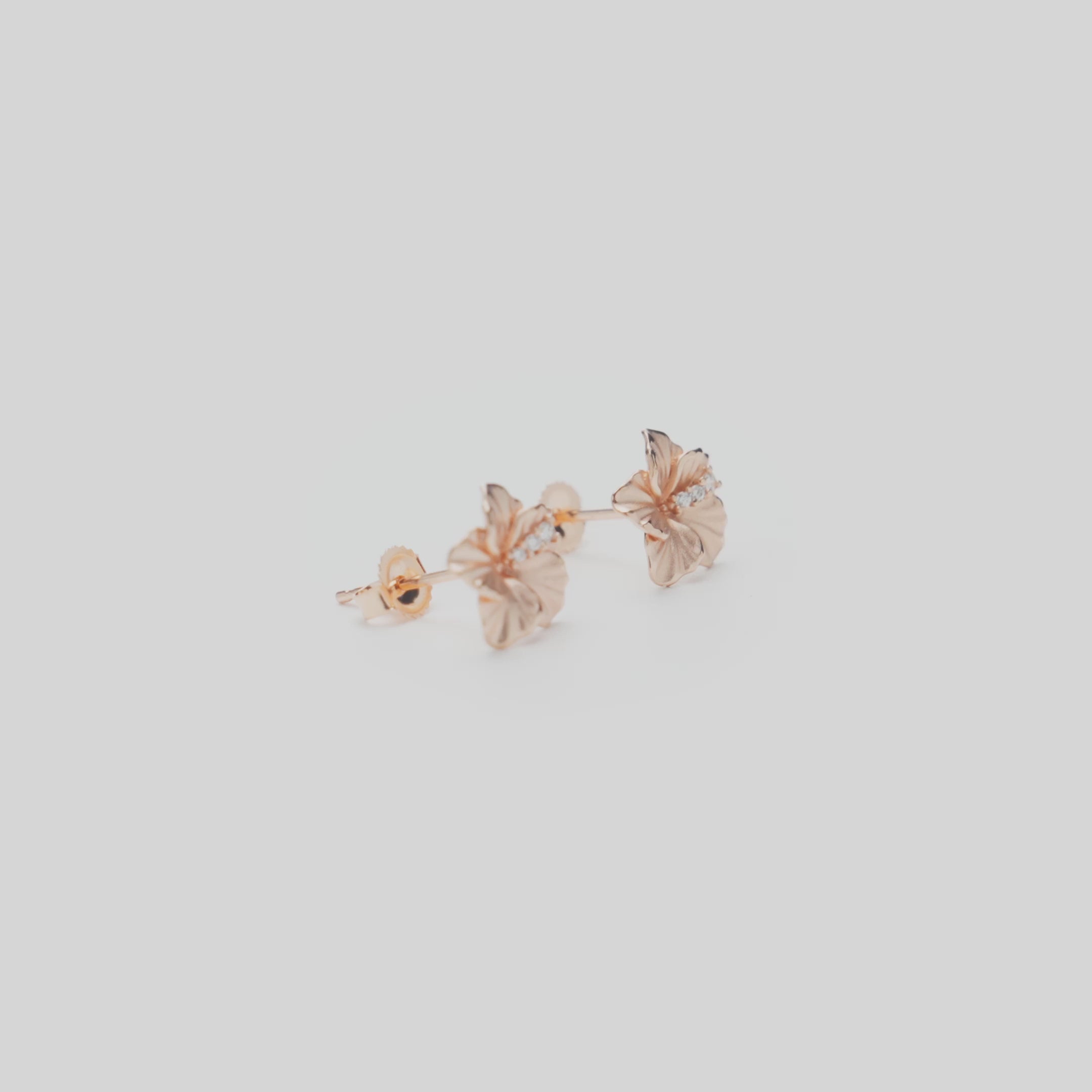 9.5mm Diamond Hibiscus Earrings in 14k Rose Gold on a white turntable
