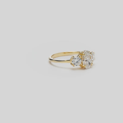Video of a Hidden Hawaiʻi Maile Three Stone Lab Grown Diamond Ring in 14k Yellow Gold on a white background
