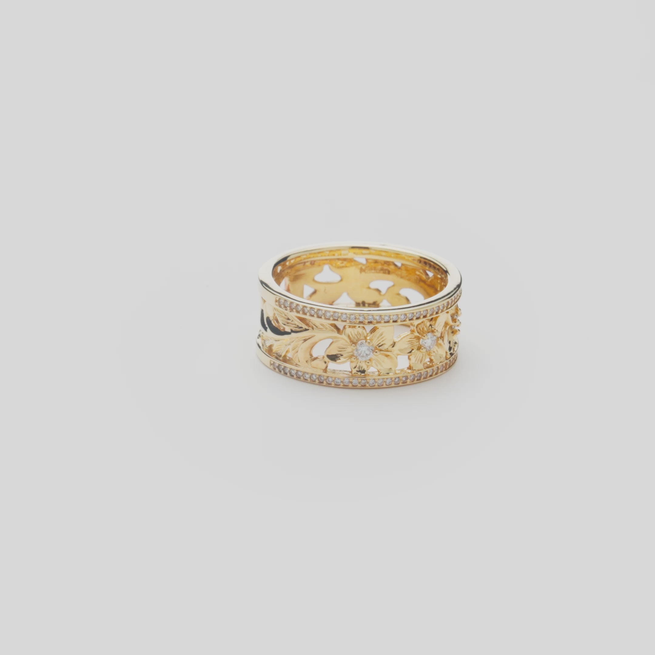 Hawaiian Heirloom Plumeria Ring in Gold with Diamonds on a white turntable